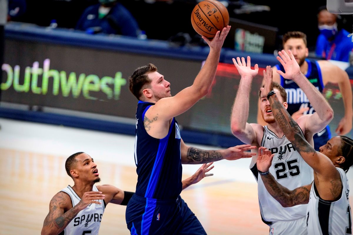 Mar 10, 2021; Dallas, Texas, USA; Dallas Mavericks guard Luka Doncic (77) shoots over San Antonio Spurs guard Dejounte Murray (5) and center Jakob Poeltl (25) and forward DeMar DeRozan (10) during the second half at the American Airlines Center. Mandatory Credit: Jerome Miron-USA TODAY Sports