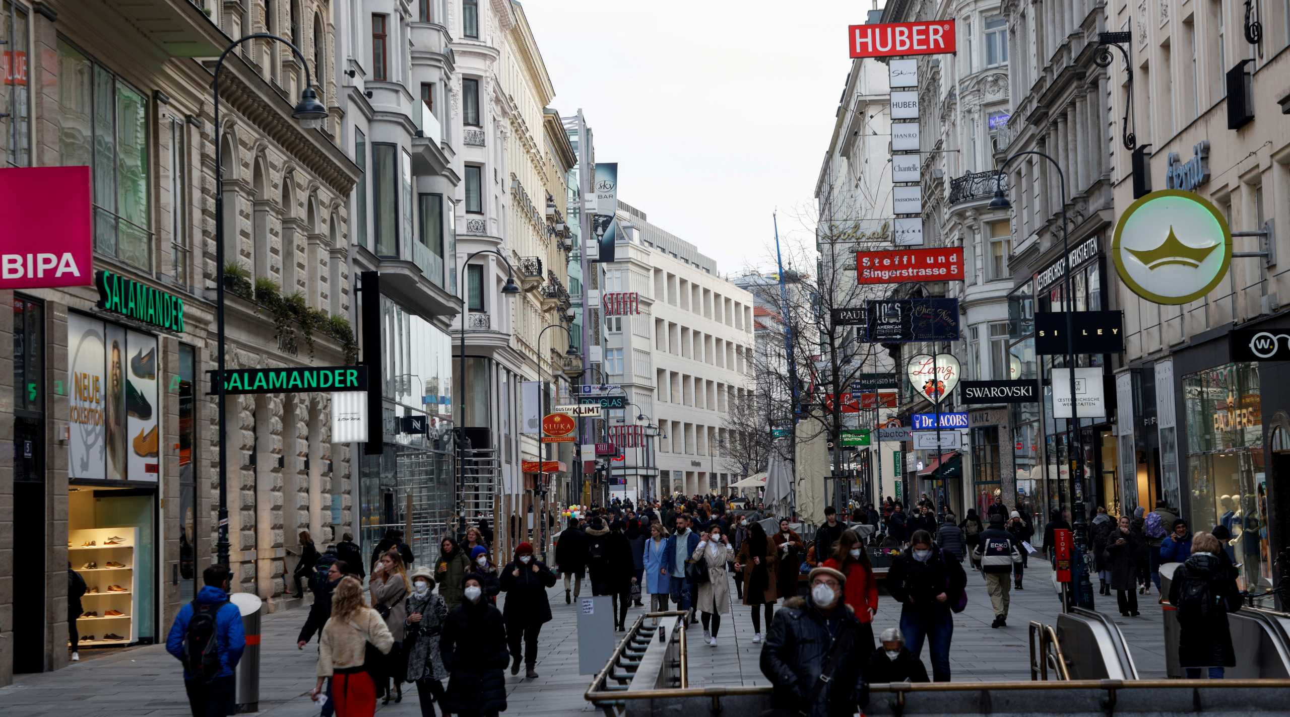People walk down a shopping street, as the local Government discusses to close non-essential shops for several days over Easter due to the coronavirus disease (COVID-19) outbreak, in Vienna, Austria March 24, 2021. REUTERS