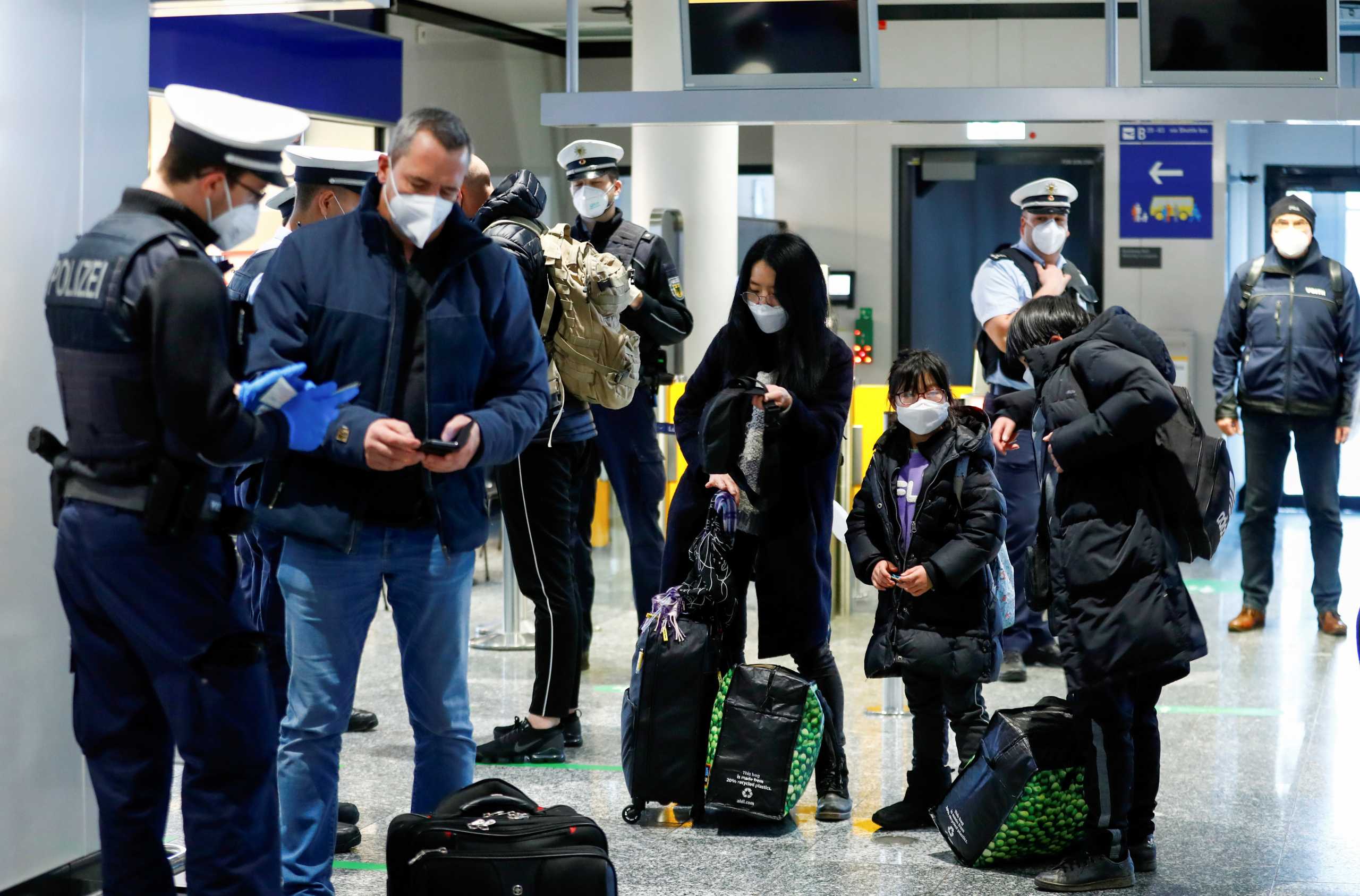 FILE PHOTO: Federal police officers check air passengers arriving from Britain at Frankfurt Airport, as the spread of the coronavirus disease (COVID-19) continues, in Frankfurt, Germany, January 30, 2021. REUTERS