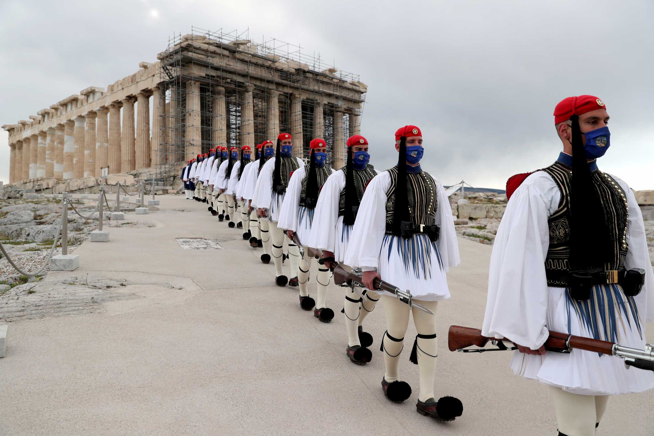 Members of the Presidential Guard walk in front of the Parthenon temple atop the Acropolis after the Greek flag raising ceremony during celebrations of the 200th anniversary of the Greek War of Independence in Athens, Greece, March 25, 2021. Petros Giannakouris