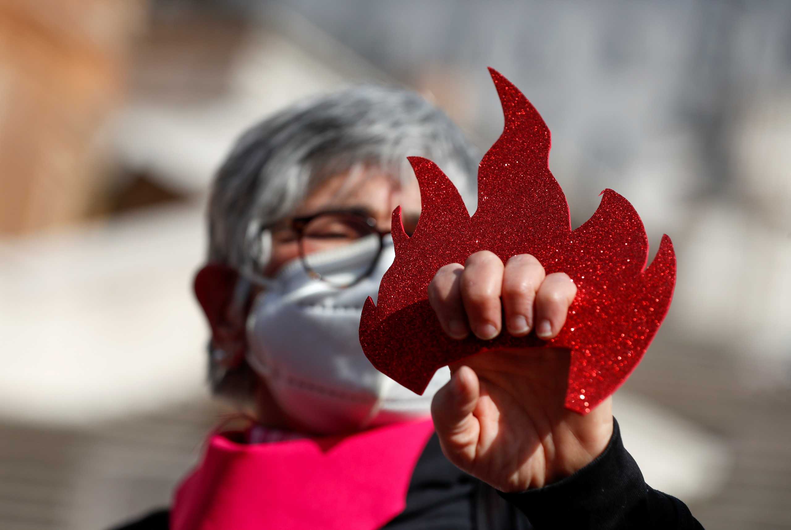 A feminist activist demonstrates at the Spanish Steps for the elimination of violence against women and to demand more government aid for those struggling financially due to the coronavirus disease (COVID-19) crisis, in Rome, Italy February 26, 2021. REUTERS