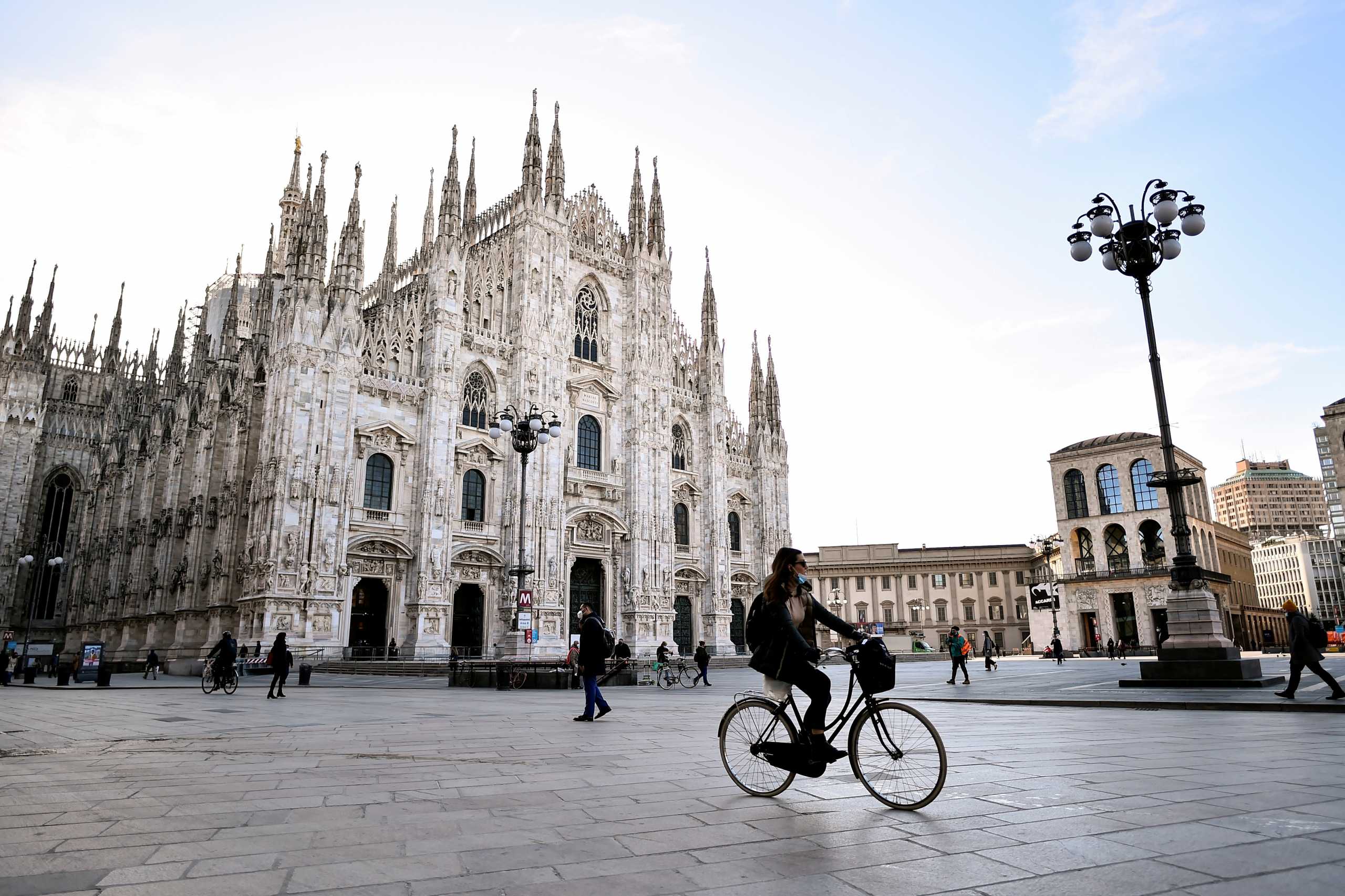 FILE PHOTO: People wearing face masks walk in Duomo square as the region of Lombardy becomes a 'red zone', going into lockdown as the country struggles to reduce the coronavirus disease (COVID-19) infections, in Milan, Italy, March 15, 2021. REUTERS