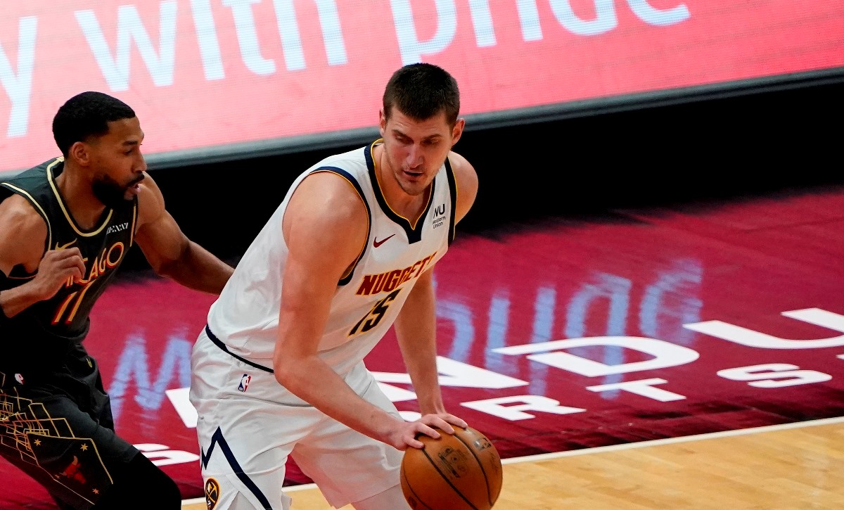 Mar 1, 2021; Chicago, Illinois, USA; Denver Nuggets center Nikola Jokic (15) dribbles the ball against Chicago Bulls guard Garrett Temple (17) during the first quarter at the United Center. Mandatory Credit: Mike Dinovo-USA TODAY Sports
