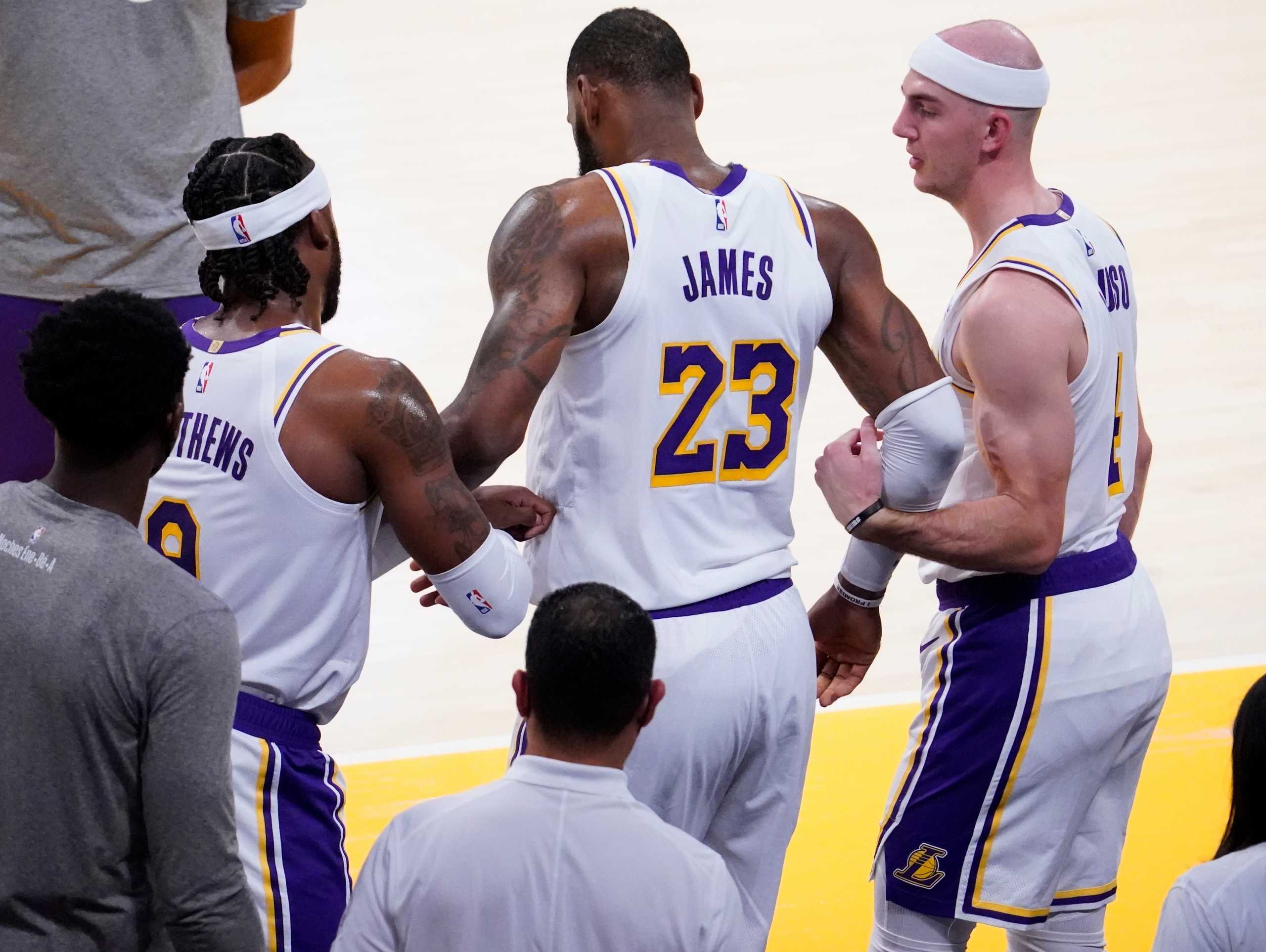 Mar 20, 2021; Los Angeles, California, USA; Los Angeles Lakers forward LeBron James (23) is helped up by Los Angeles Lakers guard Wesley Matthews (9) and Los Angeles Lakers guard Alex Caruso (4) after injuring his leg in the second quarter at Staples Center. Mandatory Credit: Robert Hanashiro-USA TODAY Sports