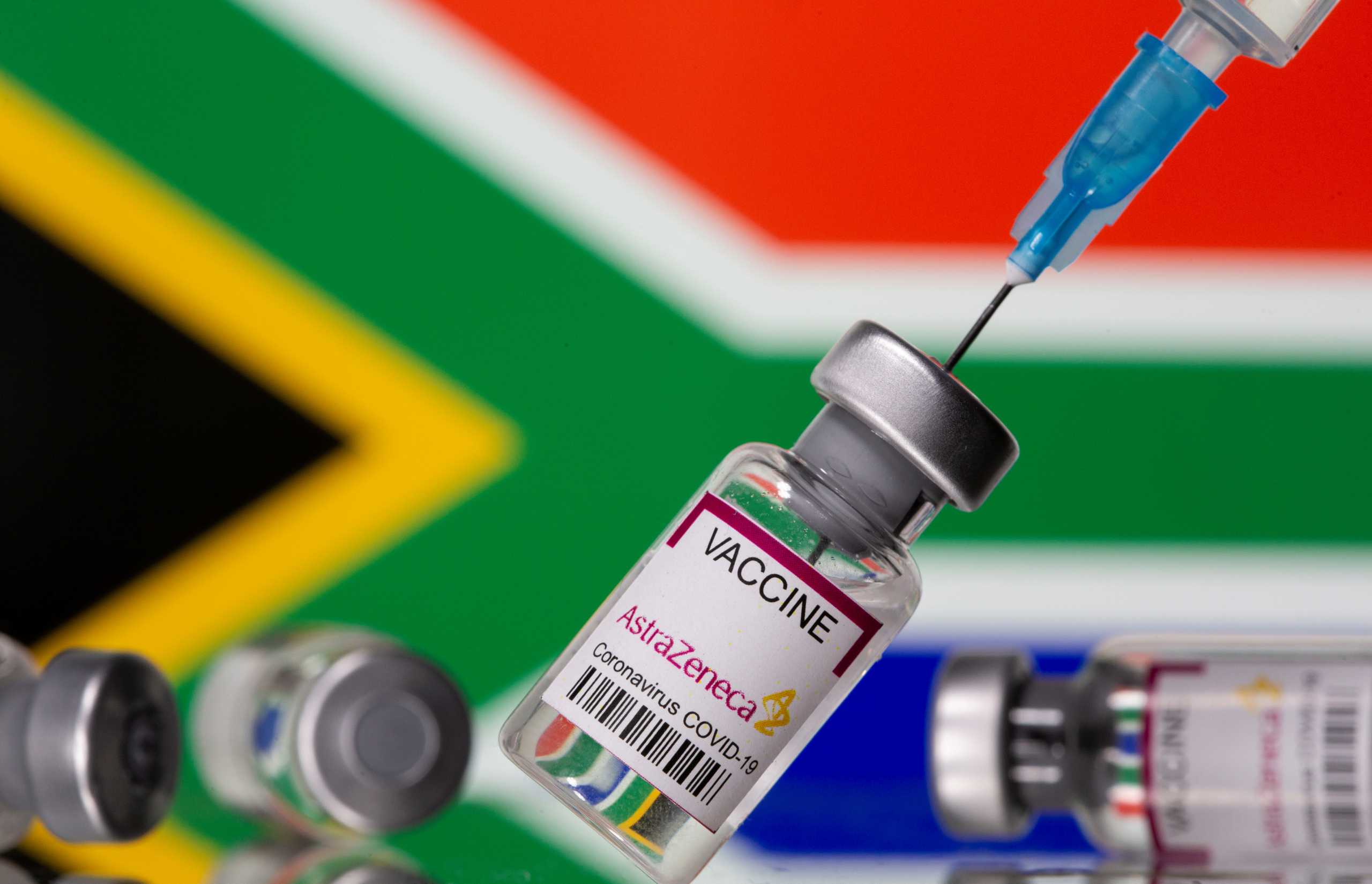 Vials labelled "Astra Zeneca COVID-19 Coronavirus Vaccine" and a syringe are seen in front of a displayed South Africa flag, in this illustration photo taken March 14, 2021. REUTERS