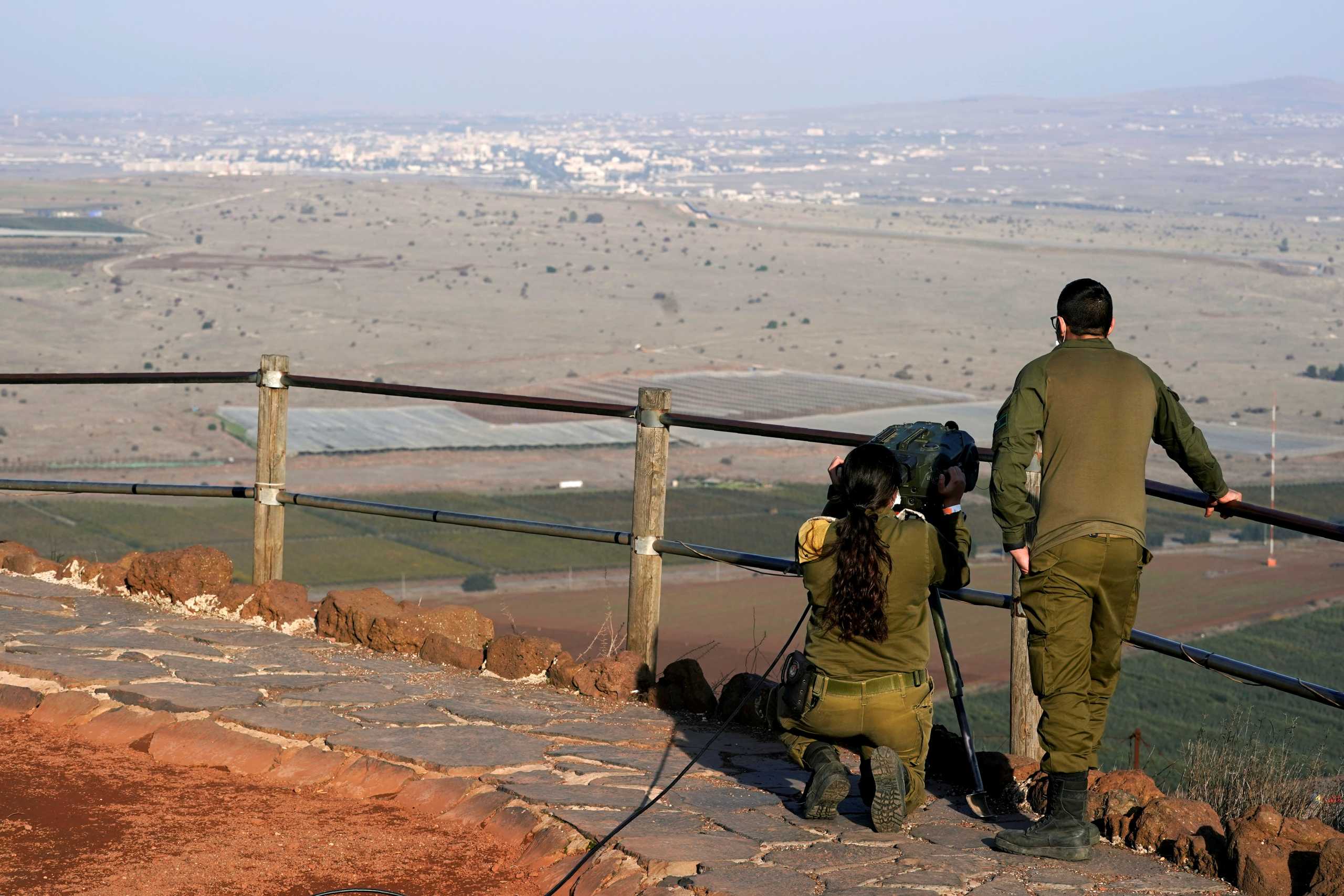 FILE PHOTO: Israeli soldiers look towards Syria across the border from Mount Bental before a visit by U.S. Secretary of State Mike Pompeo and Israeli Foreign Minister Gabi Ashkenazi in the Israeli-occupied Golan Heights November 19, 2020. Patrick Semansky