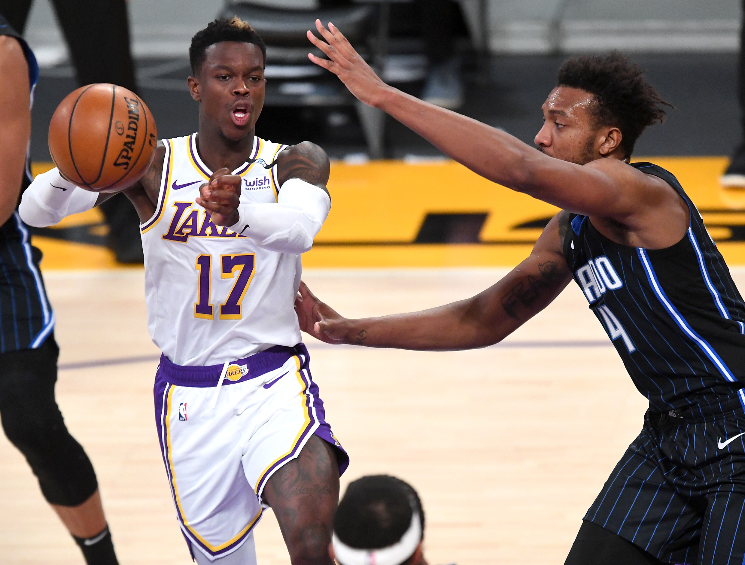 Mar 28, 2021; Los Angeles, California, USA;  Los Angeles Lakers guard Dennis Schroder (17) makes a pass as he is defended by Orlando Magic guard Karim Mane (4) in the first half at Staples Center. Mandatory Credit: Jayne Kamin-Oncea-USA TODAY Sports