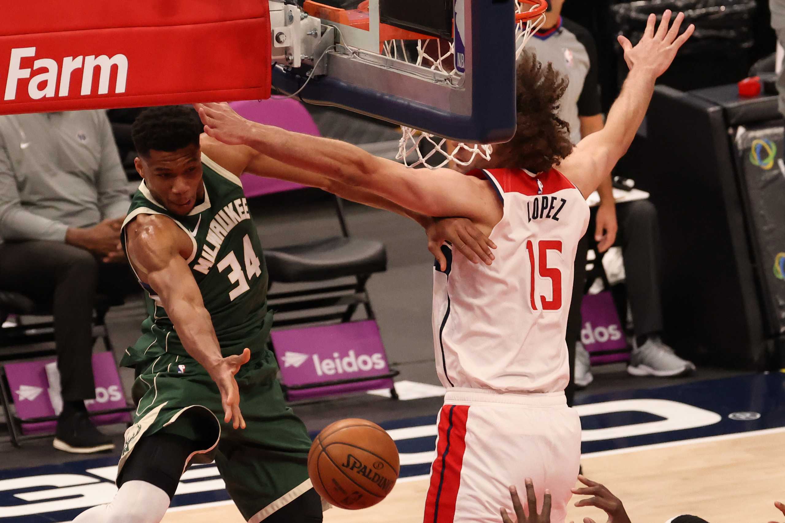 Mar 15, 2021; Washington, District of Columbia, USA; Milwaukee Bucks forward Giannis Antetokounmpo (34) passes the ball as Washington Wizards center Robin Lopez (15) defends in the first quarter at Capital One Arena. Mandatory Credit: Geoff Burke-USA TODAY Sports