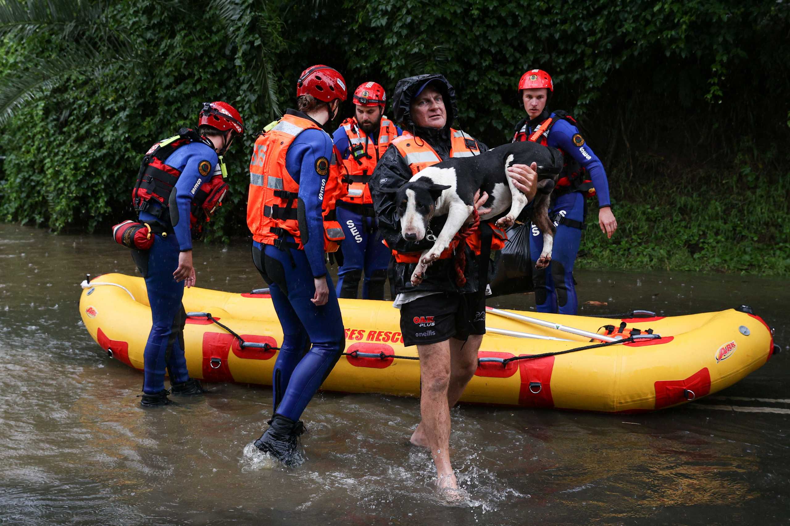 A local resident and his dog are brought to safety by a State Emergency Service rescue team in the midst of widespread flooding and severe weather across the state of New South Wales, in Sydney, Australia, March 21, 2021.  REUTERS