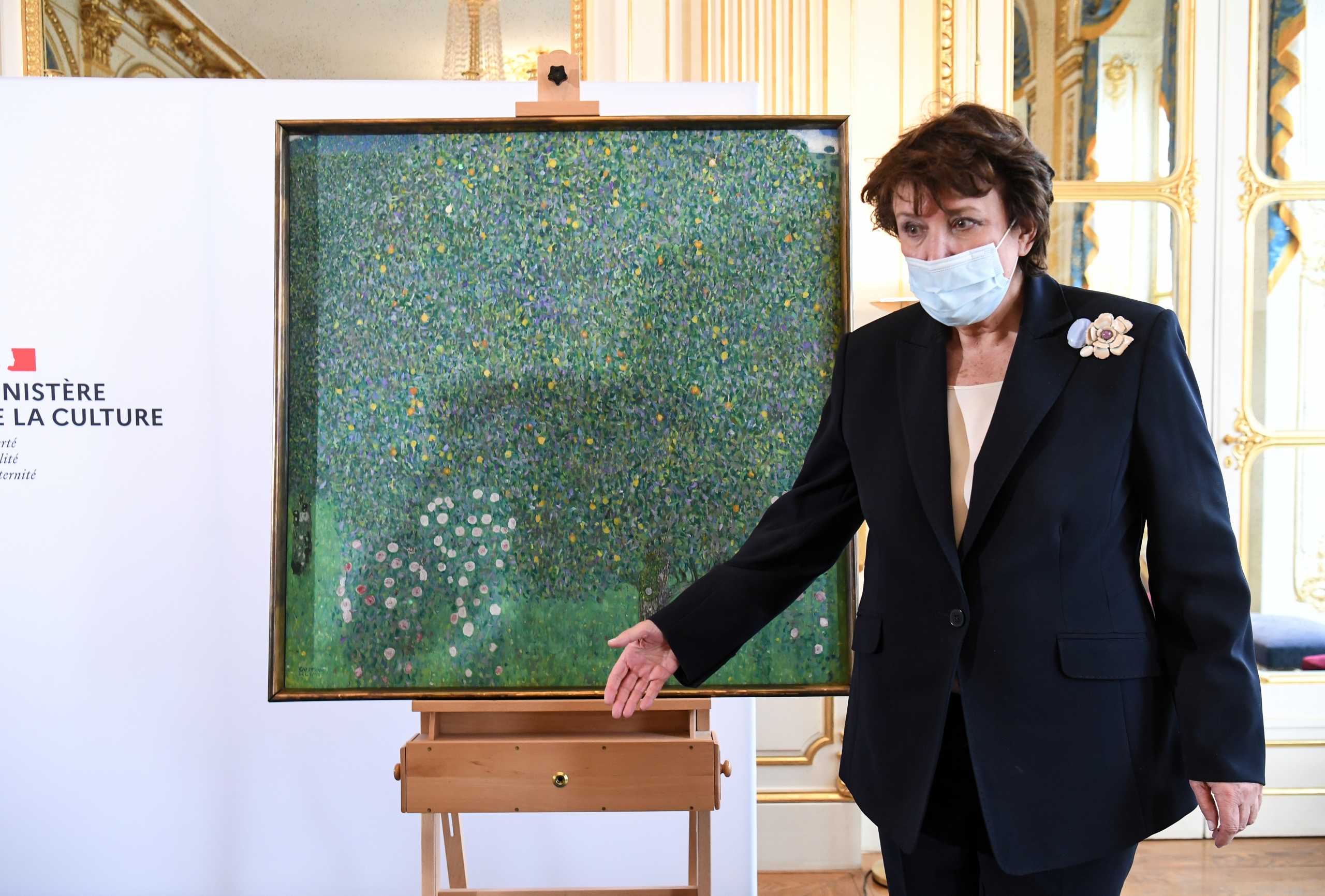 French Culture Minister Roselyne Bachelot poses next to the painting "Rosebushes under the Trees" by Austrian painter Gustav Klimt, during an event to announce the restitution of the artwork to a Jewish family from which it had been despoiled in 1938, at the Musee d'Orsay in Paris, France March 15, 2021. Alain Jocard