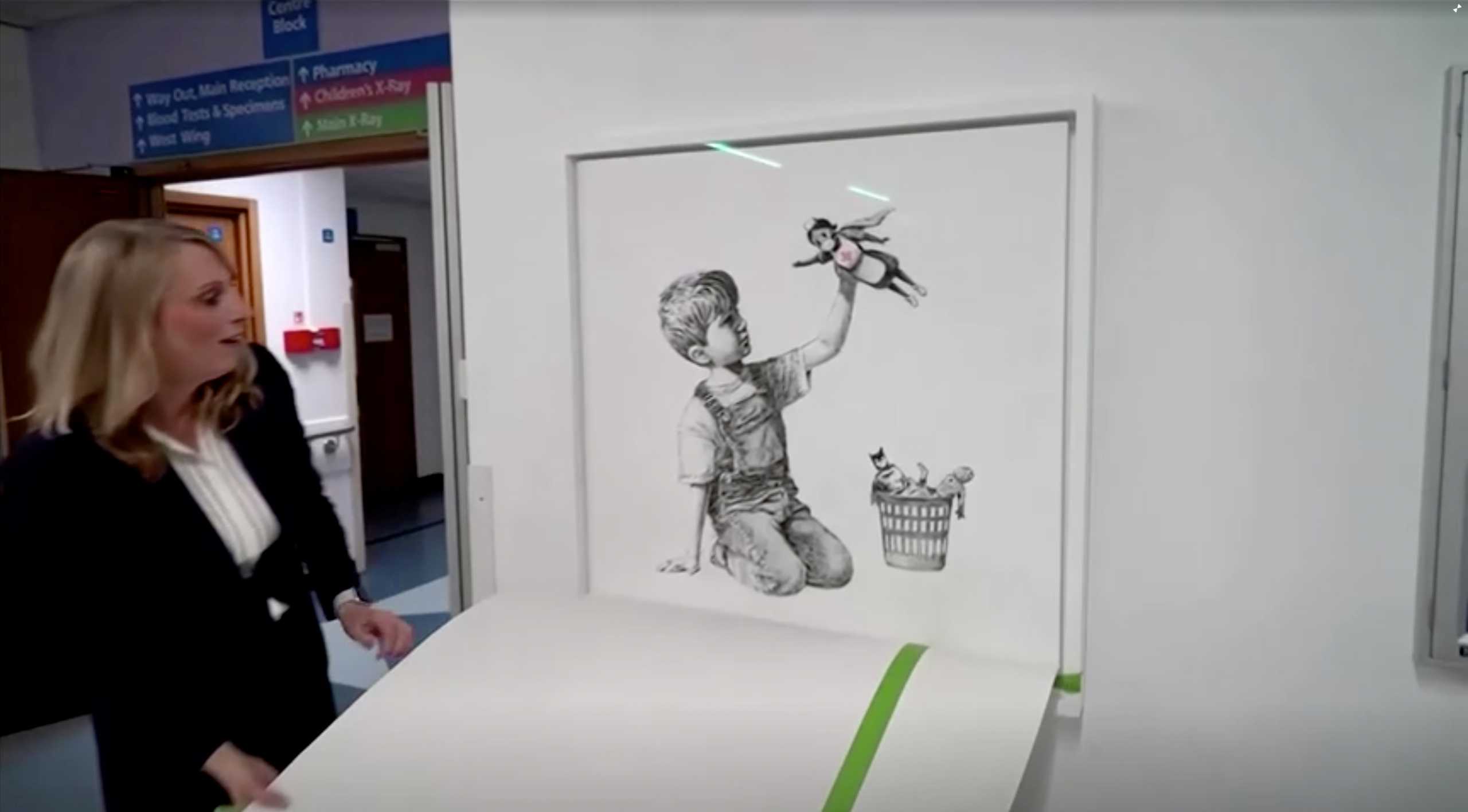 Chief executive of University Hospital Southampton NHS Foundation Trust, Paula Head, unveils Banksy's "Game Changer" artwork, in London, Britain March 16, 2021, in this still image taken from a video. BBC