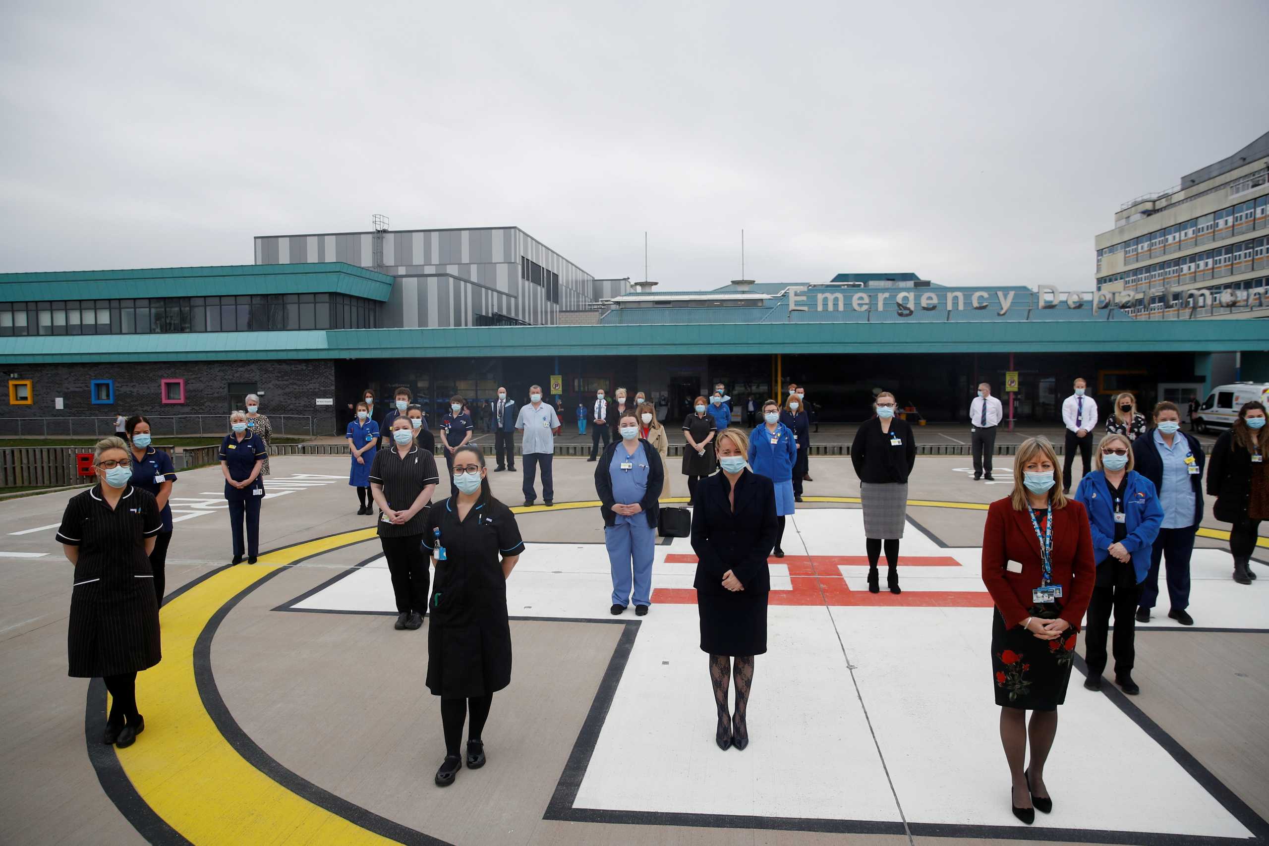 Hospital staff observe a minute's silence as part of a day of reflection to mark the anniversary of Britain's first coronavirus disease (COVID-19) lockdown, outside the Aintree University Hospital in Liverpool, Britain March 23, 2021. REUTERS