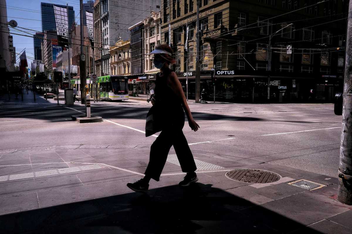 FILE PHOTO: A woman walks on a street, amid a state-wide lockdown, in Melbourne city centre, Victoria, Australia, February 15, 2021.   AAP Image