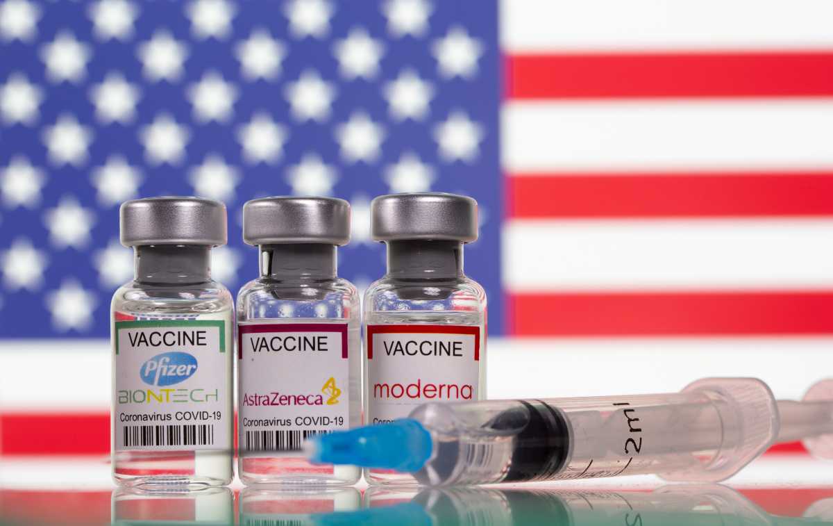 FILE PHOTO: Vials with Pfizer-BioNTech, AstraZeneca, and Moderna coronavirus disease (COVID-19) vaccine labels are seen in front of a U.S. flag in this illustration picture taken March 19, 2021. REUTERS