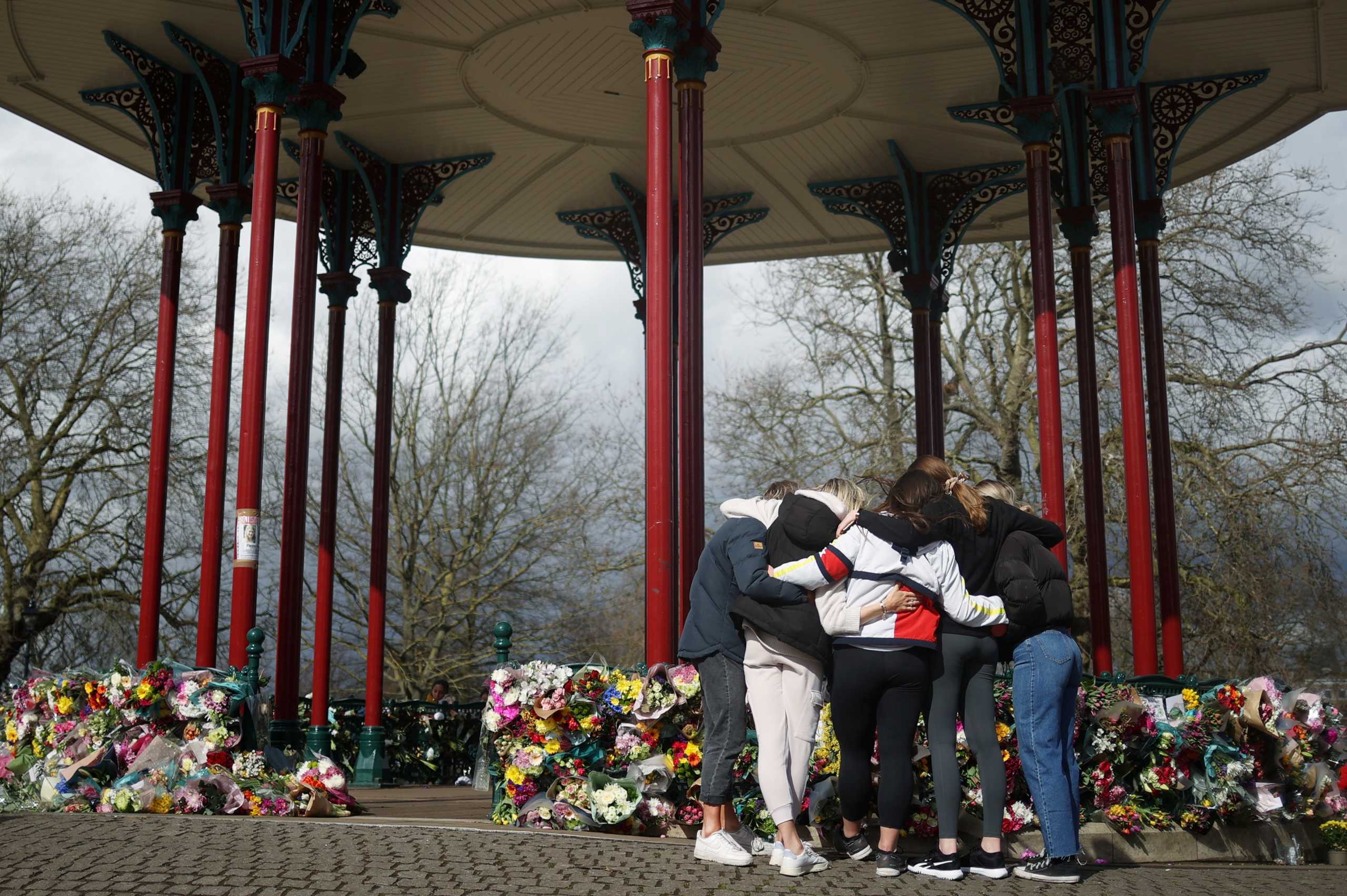 People embrace each other at a memorial site at the Clapham Common Bandstand, following the kidnap and murder of Sarah Everard, in London, Britain March 13, 2021. REUTERS