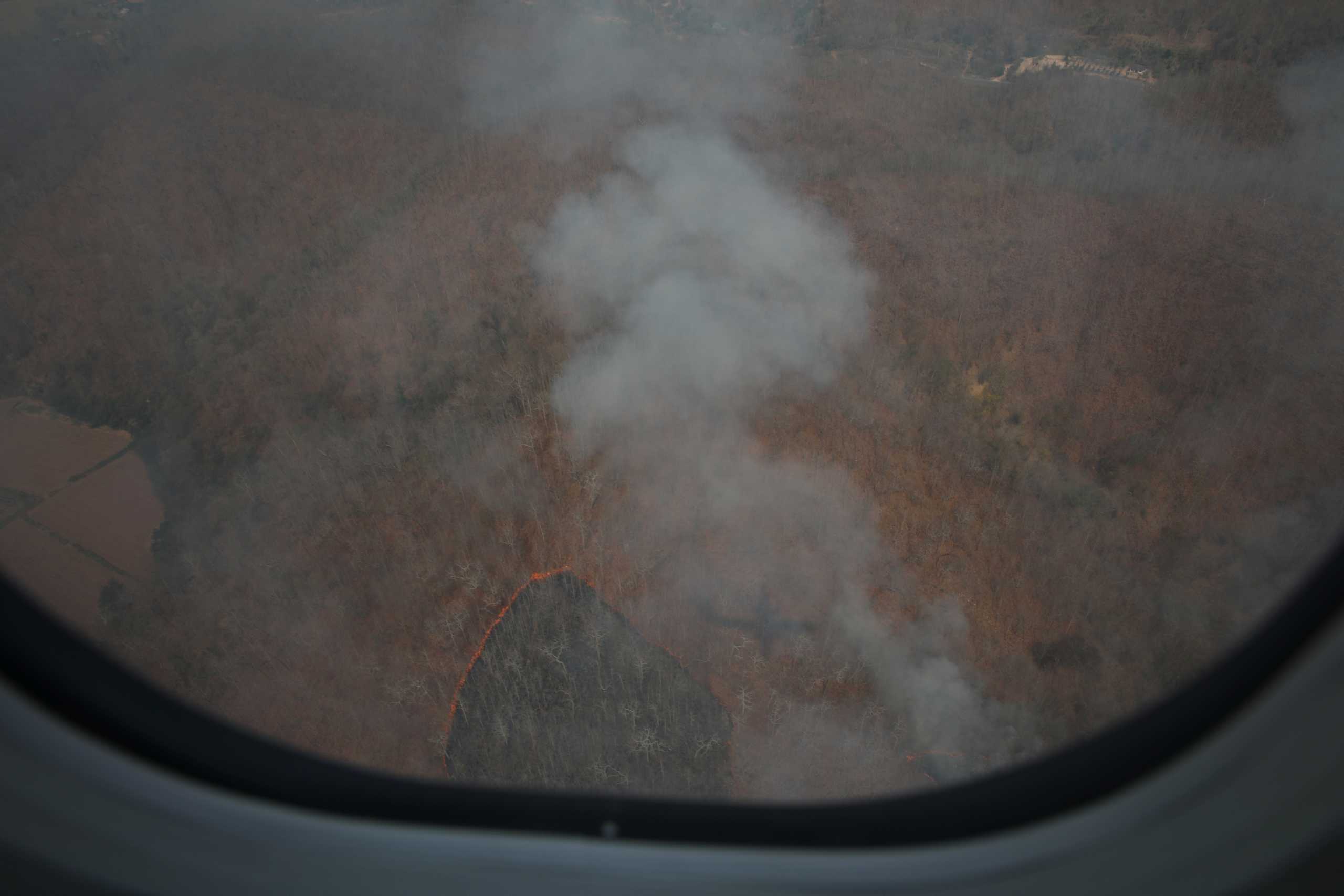 A fire of the forest is seen from the window of an airplane in Mae Hong Son, Thailand March 24, 2021. Picture taken on March 24, 2021. REUTERS