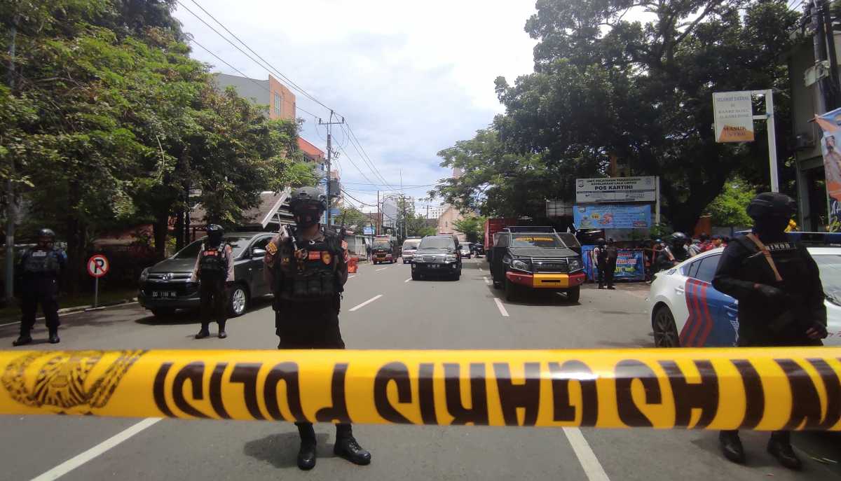 Armed police officers stand guard along a closed road following an explosion outside a Catholic church in Makassar, South Sulawesi province, Indonesia, March 28, 2021. REUTERS