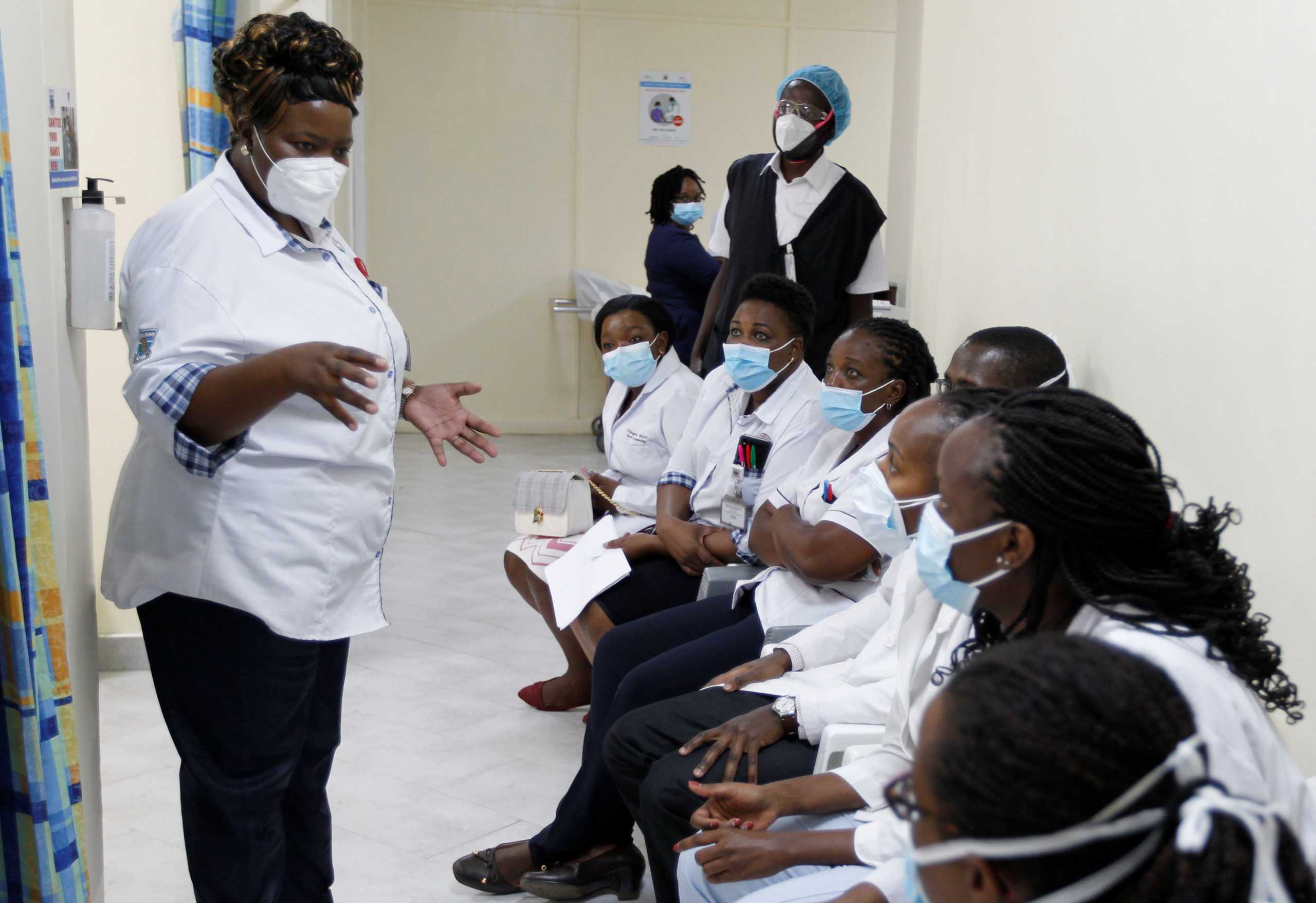 A health worker talks to her colleagues as they prepare to receive the AstraZeneca