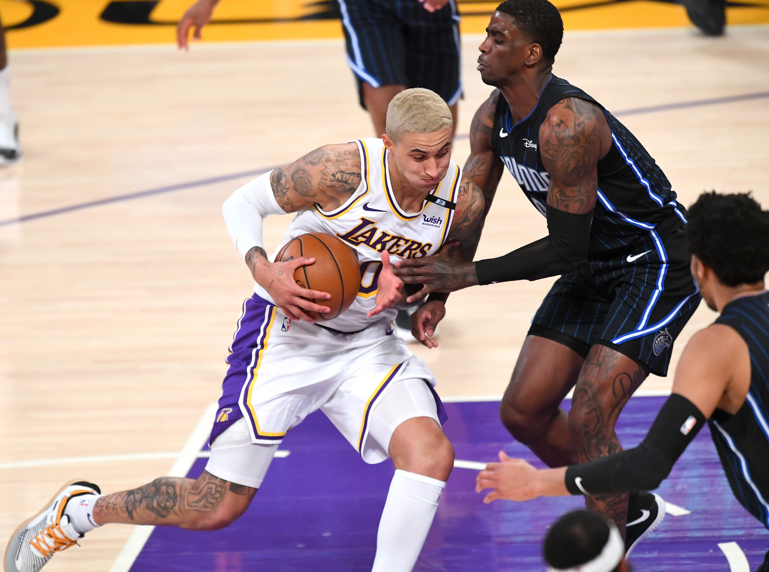 Mar 28, 2021; Los Angeles, California, USA;  Los Angeles Lakers forward Kyle Kuzma (0) is guarded by Orlando Magic guard Dwayne Bacon (8) as he drives to the basket in the first half at Staples Center. Mandatory Credit: Jayne Kamin-Oncea-USA TODAY Sports