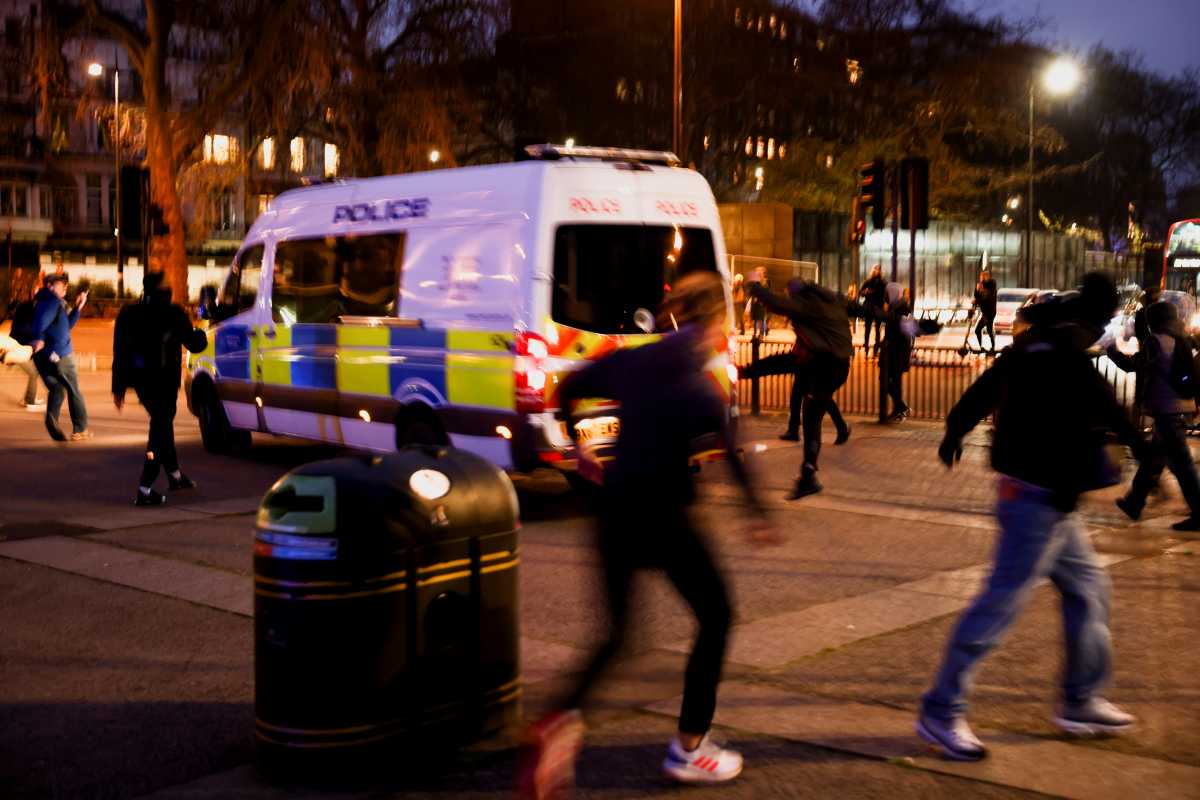 A person kicks a police vehicle during a protest against the lockdown, amid the spread of the coronavirus disease (COVID-19), in London, Britain March 20, 2021. REUTERS