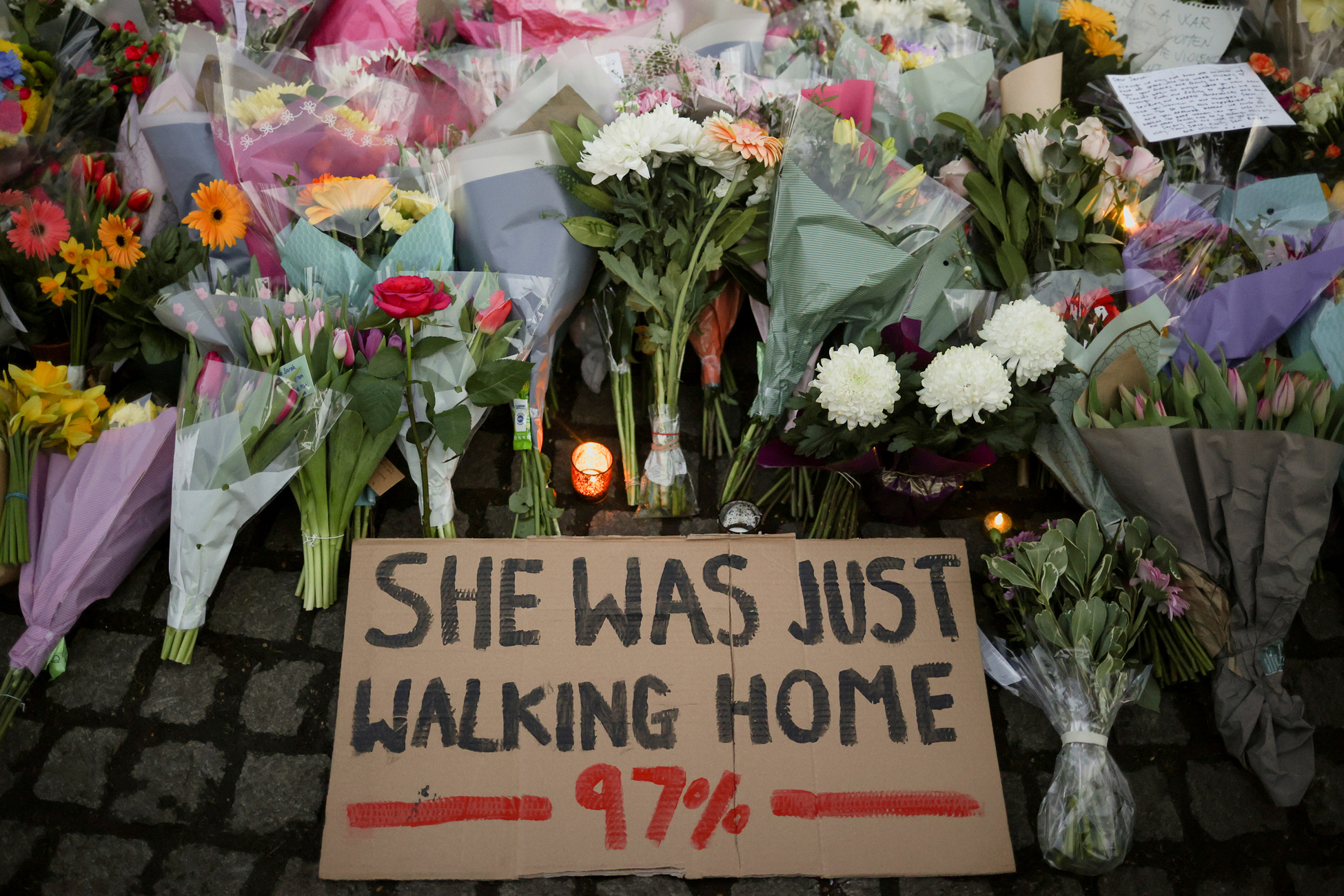 A sign is seen as people gather at a memorial site in Clapham Common Bandstand, following the kidnap and murder of Sarah Everard, in London, Britain March 13, 2021. REUTERS