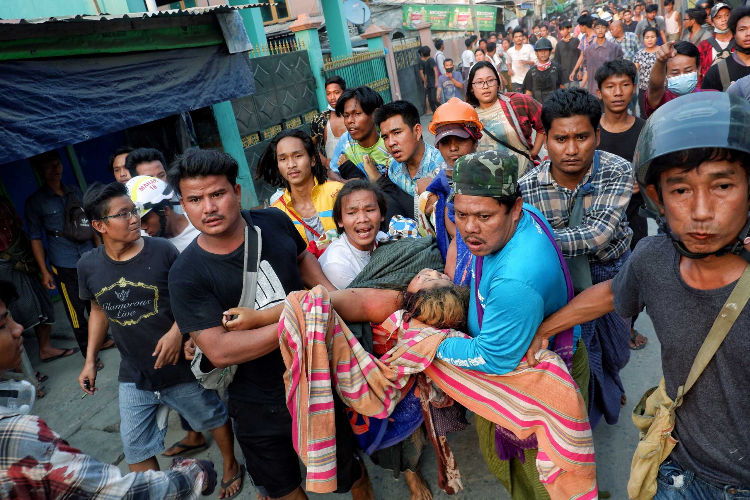 SENSITIVE MATERIAL. THIS IMAGE MAY OFFEND OR DISTURB People pull out Shell Ye Win 24 who was shot during the security force crack down on anti-coup protesters in Mandalay, Myanmar March 14, 2021. REUTERS