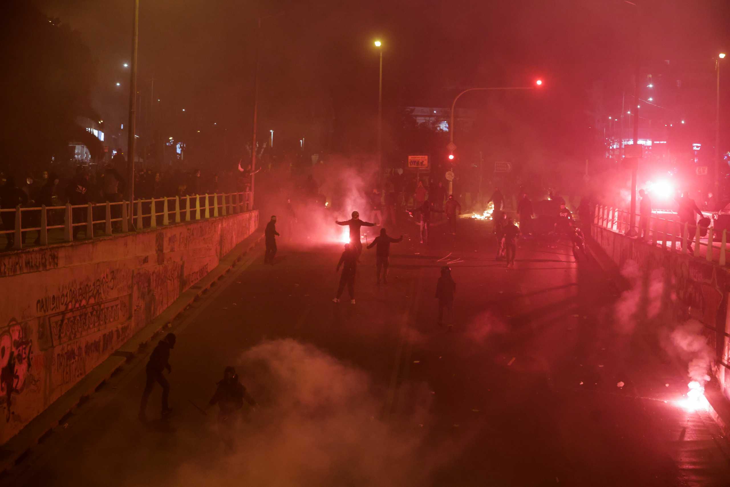 Flares burn near protesters, as they clash with police officers during a demonstration against a police crackdown on gatherings, in Athens, Greece, March 9, 2021. REUTERS