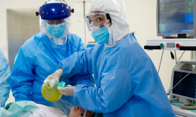 Emergency room, nurses using a medical ventilator on a patient