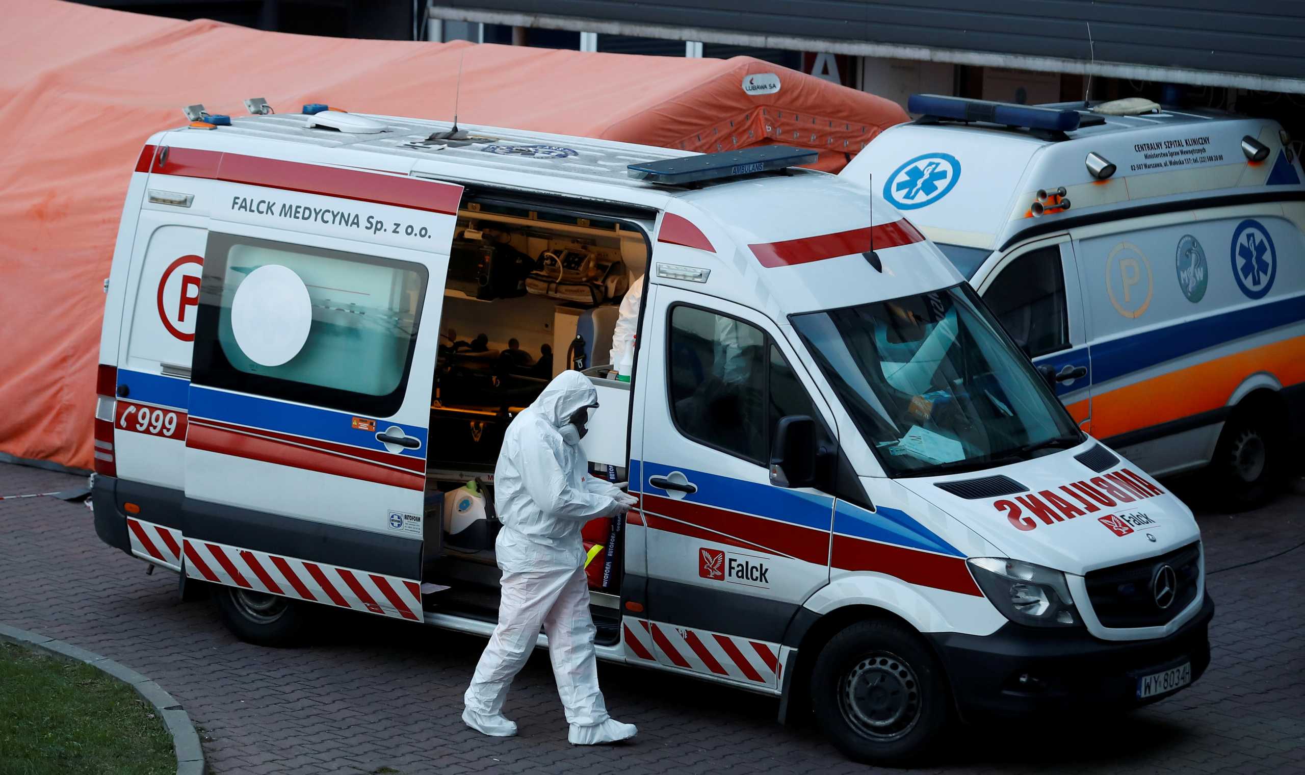 FILE PHOTO: A paramedic walks near an ambulance amid the coronavirus disease (COVID-19) outbreak, in front of a hospital in Warsaw, Poland December 3, 2020. REUTERS