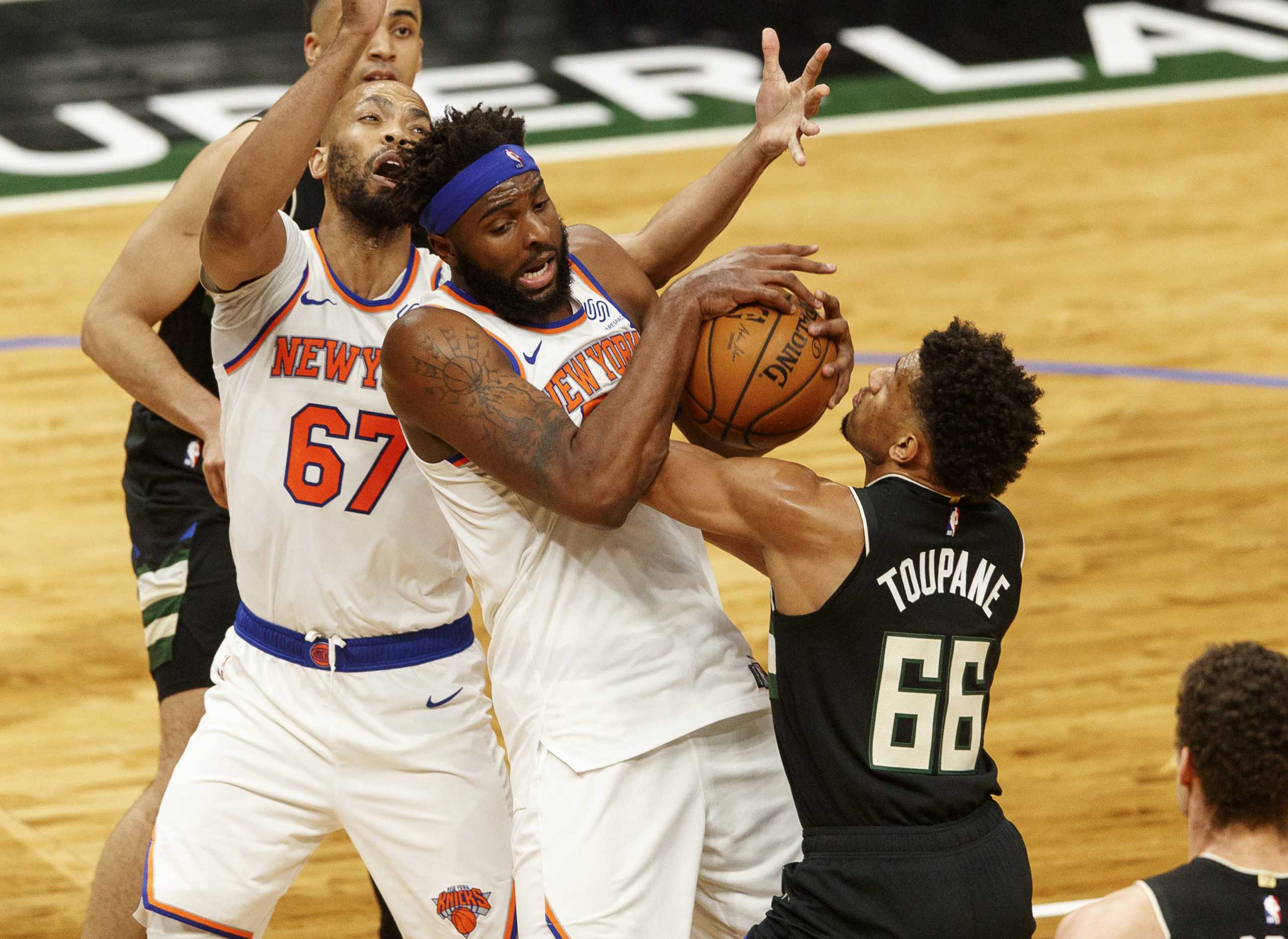 Mar 27, 2021; Milwaukee, Wisconsin, USA;  New York Knicks center Mitchell Robinson (23) battles Milwaukee Bucks forward Axel Toupane (66) for control of the ball during the first quarter at Fiserv Forum. Mandatory Credit: Jeff Hanisch-USA TODAY Sports