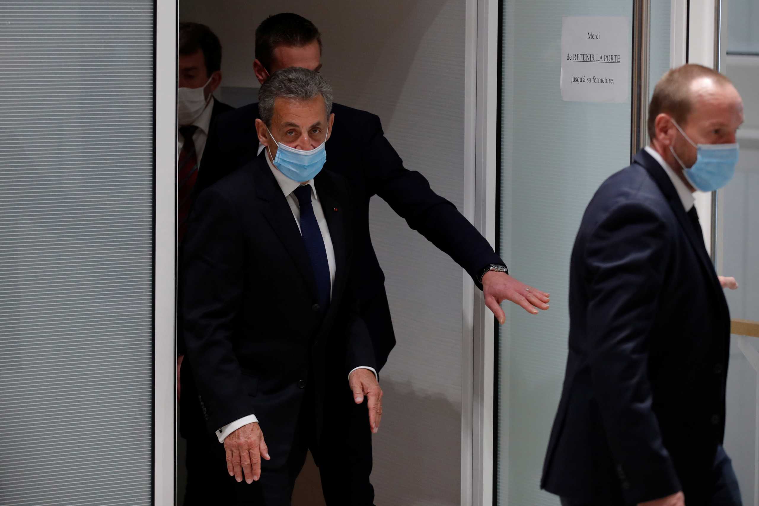 Former French President Nicolas Sarkozy, wearing a protective face mask, leaves after the verdict in his trial on charges of corruption and influence peddling, at Paris courthouse, France, March 1, 2021. REUTERS