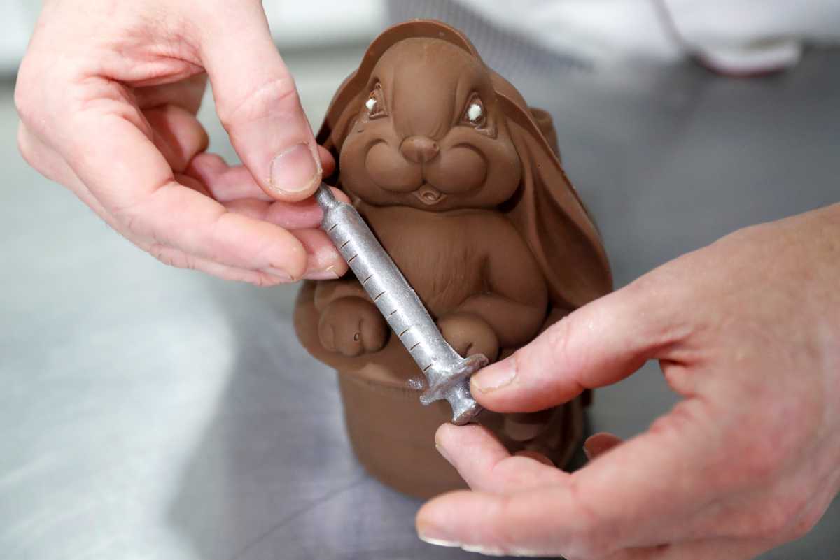 Hungarian confectioner Laszlo Rimoczi works on a chocolate Easter bunny holding a syringe at his workshop, during the coronavirus disease (COVID-19) pandemic, in Lajosmizse, Hungary, March 9, 2021. Picture taken March 9, 2021. REUTERS