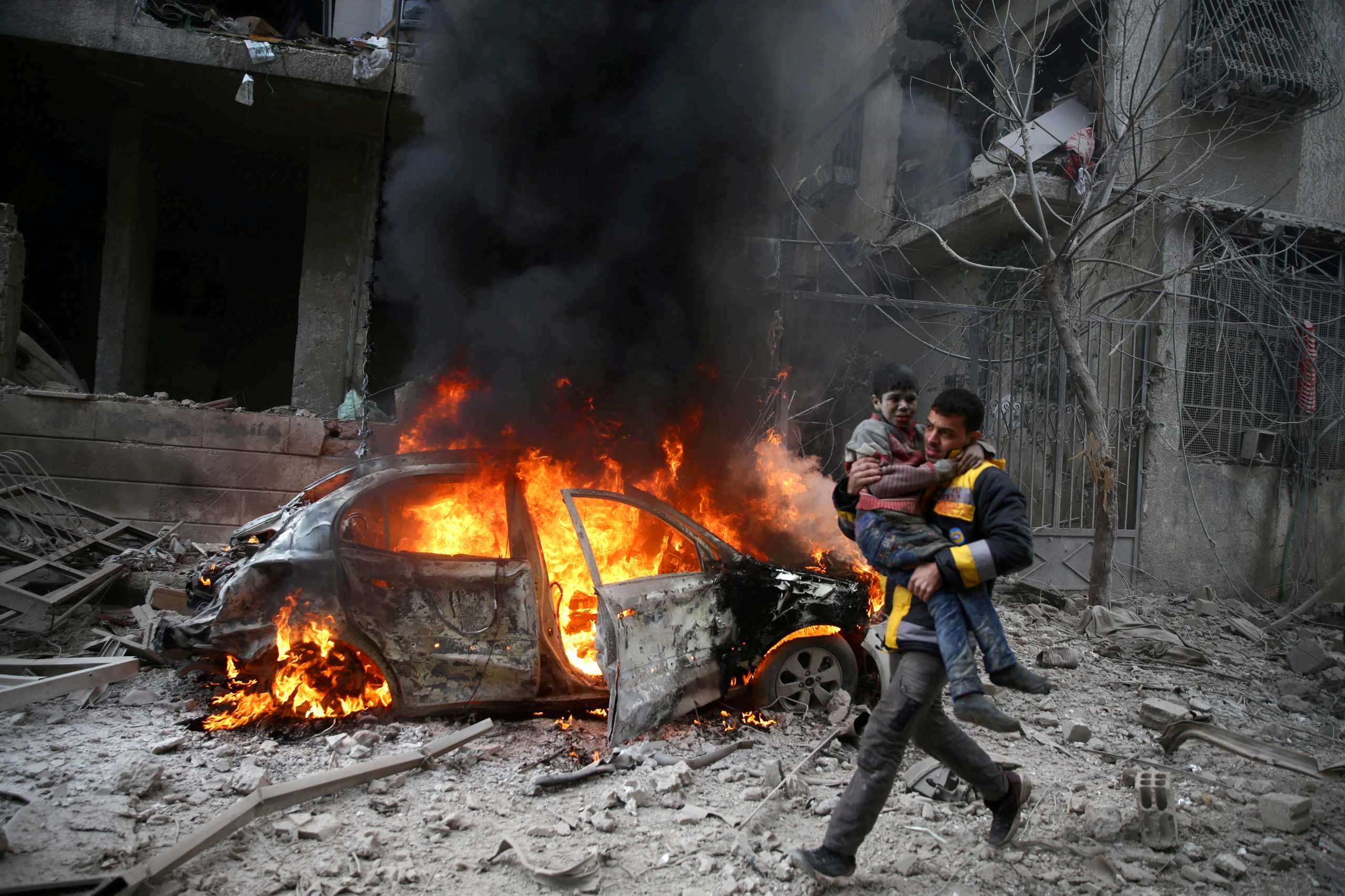 FILE PHOTO: A Syrian Civil Defence member carries a wounded child in the besieged town of Hamoria, Eastern Ghouta, in Damascus, Syria January 6, 2018. REUTERS