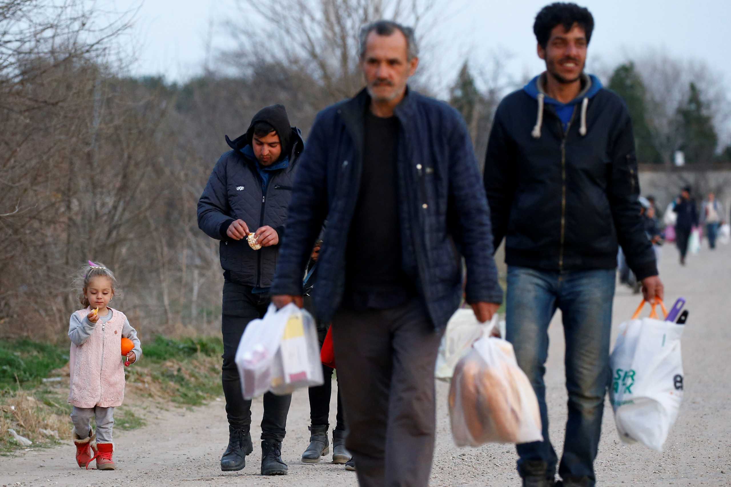 FILE PHOTO: Migrants walk towards Turkey's Pazarkule border crossing with Greece's Kastanies, in Edirne, Turkey March 8, 2020. REUTERS