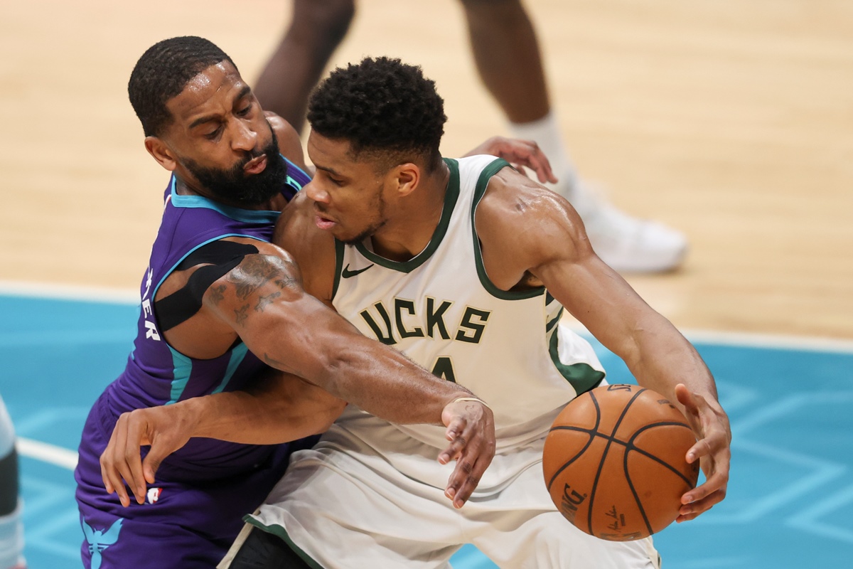 Apr 27, 2021; Charlotte, North Carolina, USA; Milwaukee Bucks forward Giannis Antetokounmpo (34) dribbles against Charlotte Hornets guard Brad Wanamaker (9) during the second quarter at Spectrum Center. Mandatory Credit: Nell Redmond-USA TODAY Sports