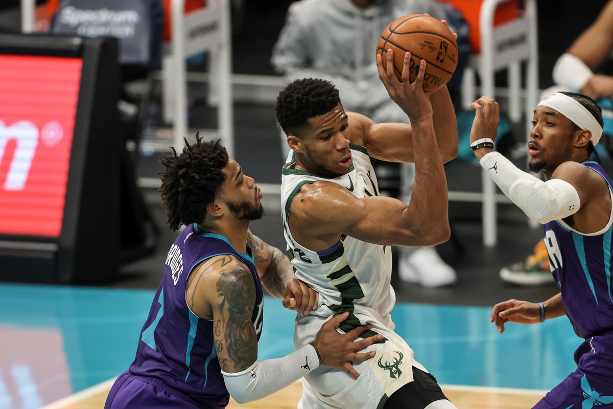 Apr 27, 2021; Charlotte, North Carolina, USA; Milwaukee Bucks forward Giannis Antetokounmpo (34) looks to pass out of a doubleteam by Charlotte Hornets forward Miles Bridges, left, and guard Devonte' Graham (4) during the second quarter at Spectrum Center. Mandatory Credit: Nell Redmond-USA TODAY Sports