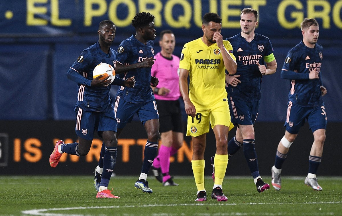 Soccer Football - Europa League - Semi Final First Leg - Villarreal v Arsenal - Estadio de la Ceramica, Villarreal, Spain - April 29, 2021 Villarreal's Francis Coquelin looks dejected Arsenal's Nicolas Pepe celebrates scoring their first goal with teammates REUTERS
