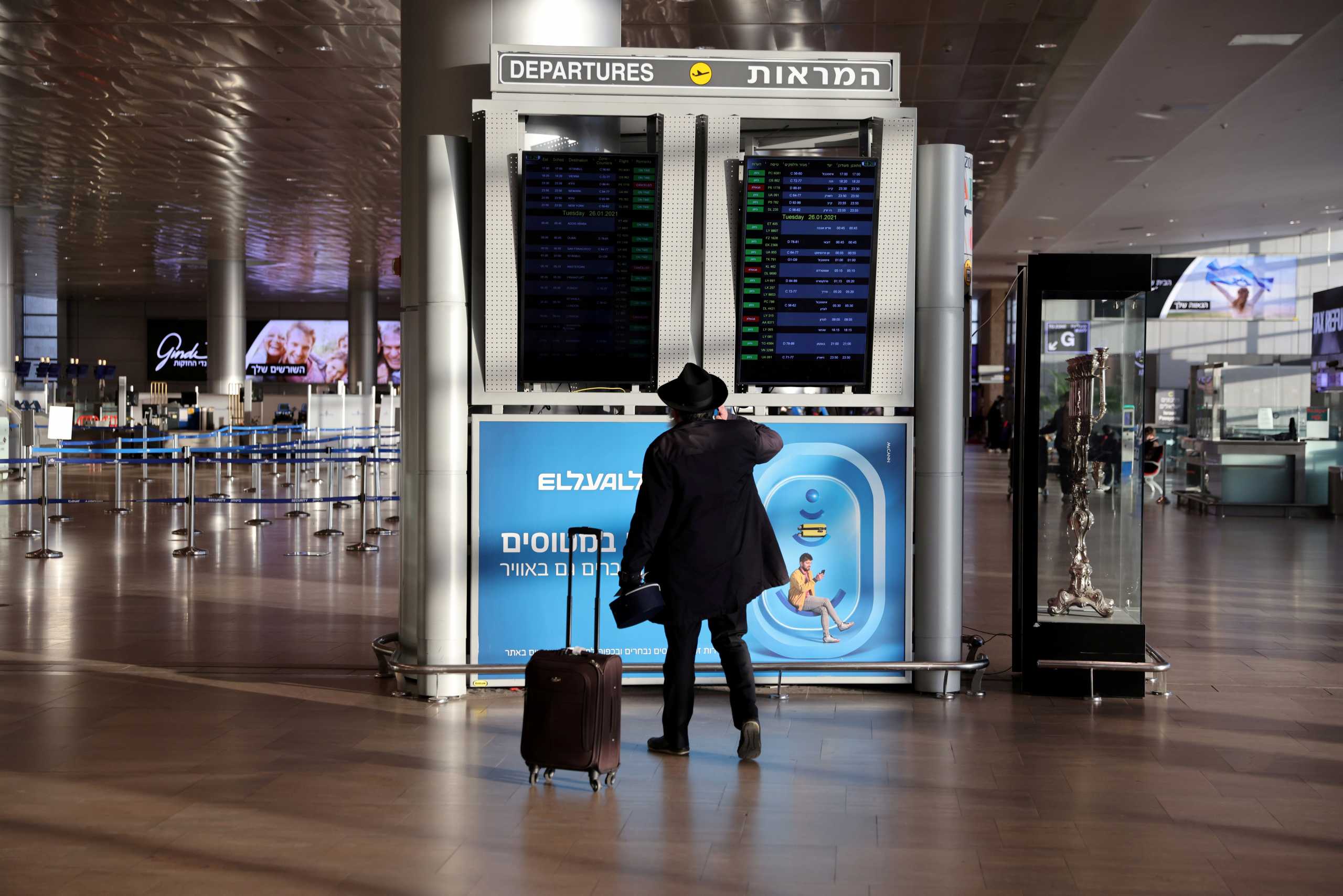 FILE PHOTO: A passenger looks at the information monitor inside a terminal at Ben Gurion international airport before Israel bans international flights, taking effect from Monday midnight until the end of January, in order to stop the spread of the coronavirus disease (COVID-19) and new coronavirus strains, in Lod near Tel Aviv, Israel January 25, 2021. REUTERS