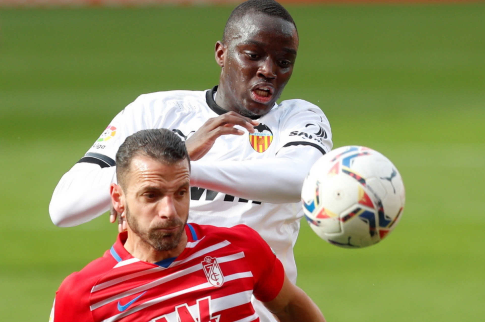 epa09088181 Valencia's defender Mouctar Diakhaby (R) vies for the ball against Granada's striker Roberto Soldado (L) during the Spanish LaLiga soccer match between Valencia CF and Granada CF at Mestalla stadium in Valencia, eastern Spain, 21 March 2021.  EPA