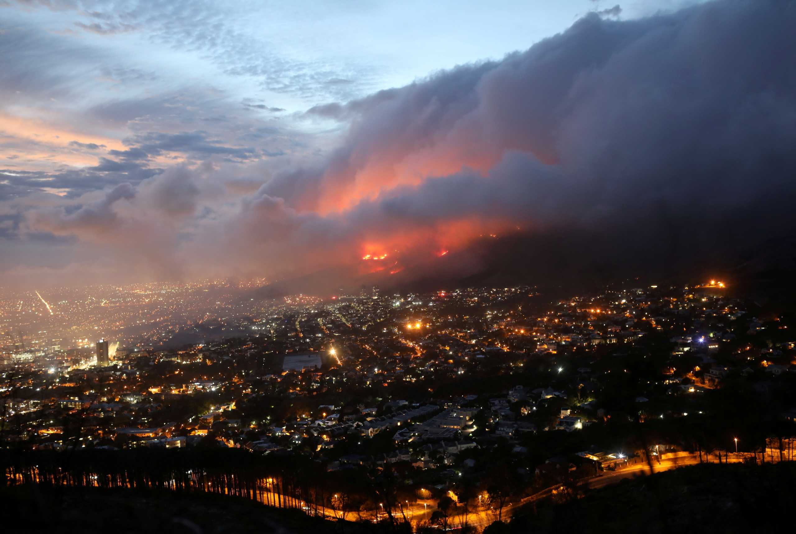 Flames are seen close to the city fanned by strong winds after  a bushfire  broke out on the slopes of Table Mountain in Cape Town, South Africa, April 19, 2021. REUTERS