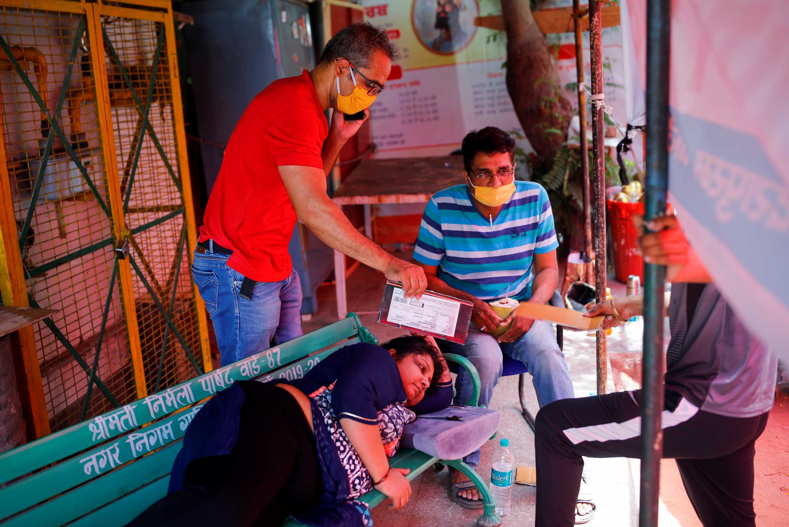 A woman suffering from a breathing difficulty due to the coronavirus disease (COVID-19) waits to receive oxygen support for free outside a Gurudwara (Sikh temple) in Ghaziabad, India, April 27, 2021. REUTERS
