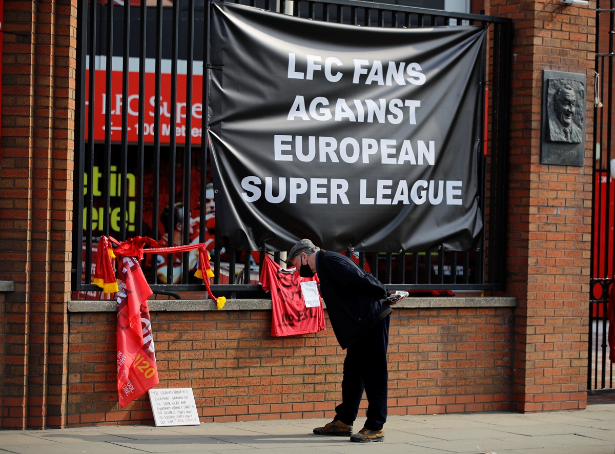 Soccer Football - Twelve of Europe's top football clubs launch a breakaway Super League - Liverpool, Britain - April 20, 2021   A man stands in front of anti Super League banners outside Anfield as twelve of Europe's top football clubs launch a breakaway REUTERS