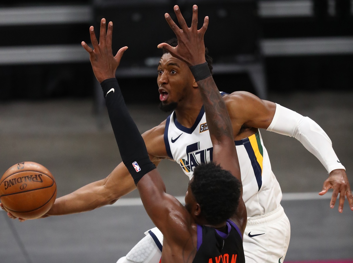 Apr 7, 2021; Phoenix, Arizona, USA; Utah Jazz guard Donovan Mitchell (45) drives to the basket against Phoenix Suns center Deandre Ayton during overtime at Phoenix Suns Arena. Mandatory Credit: Mark J. Rebilas-USA TODAY Sports