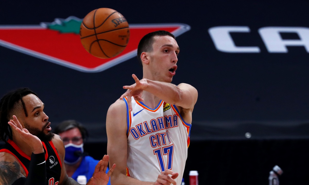Apr 18, 2021; Tampa, Florida, USA; Oklahoma City Thunder forward Aleksej Pokusevski (17) passes the ball as Toronto Raptors guard Gary Trent Jr. (33) defends during the first half at Amalie Arena. Mandatory Credit: Kim Klement-USA TODAY Sports