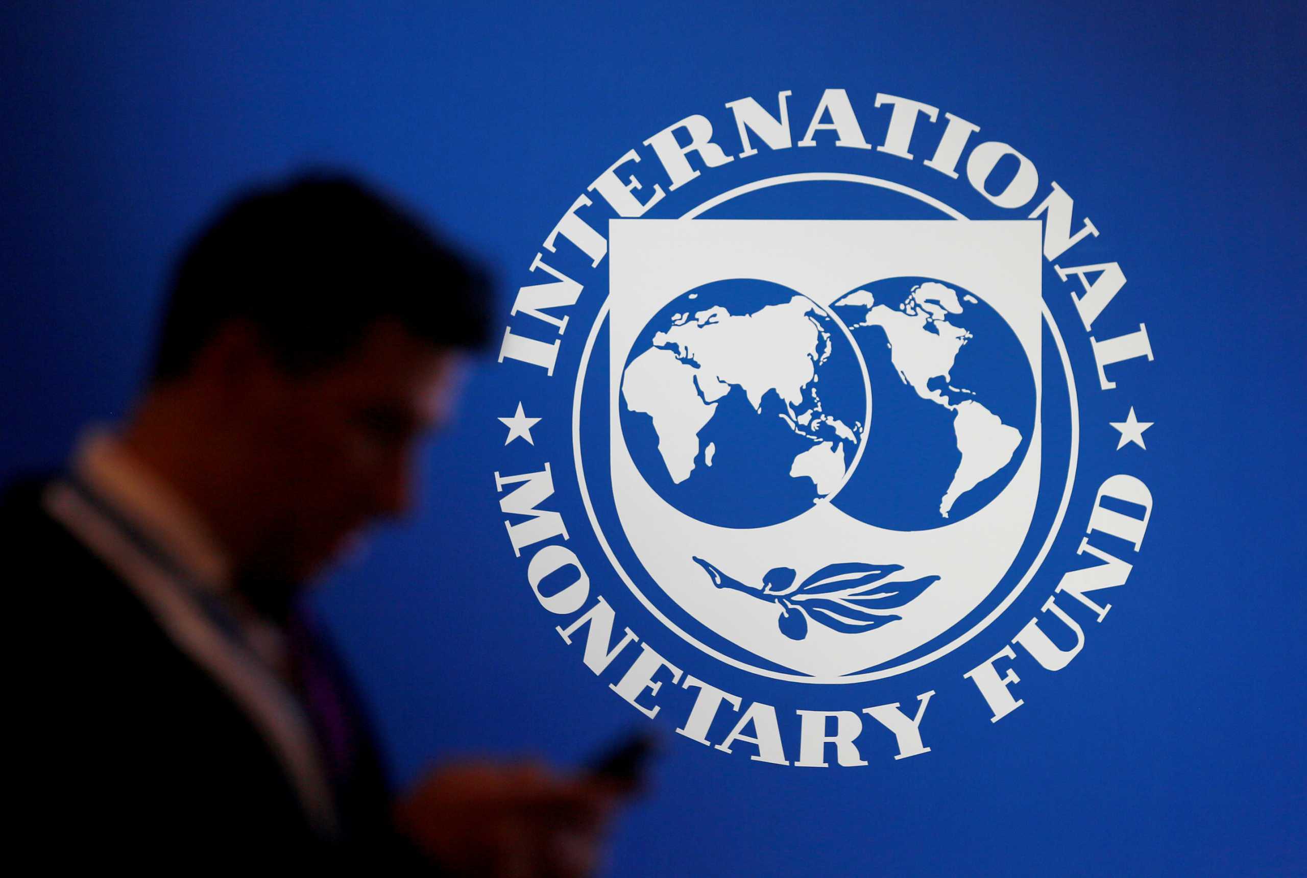 FILE PHOTO: A participant stands near a logo of IMF at the International Monetary Fund - World Bank Annual Meeting 2018 in Nusa Dua, Bali, Indonesia, October 12, 2018. REUTERS