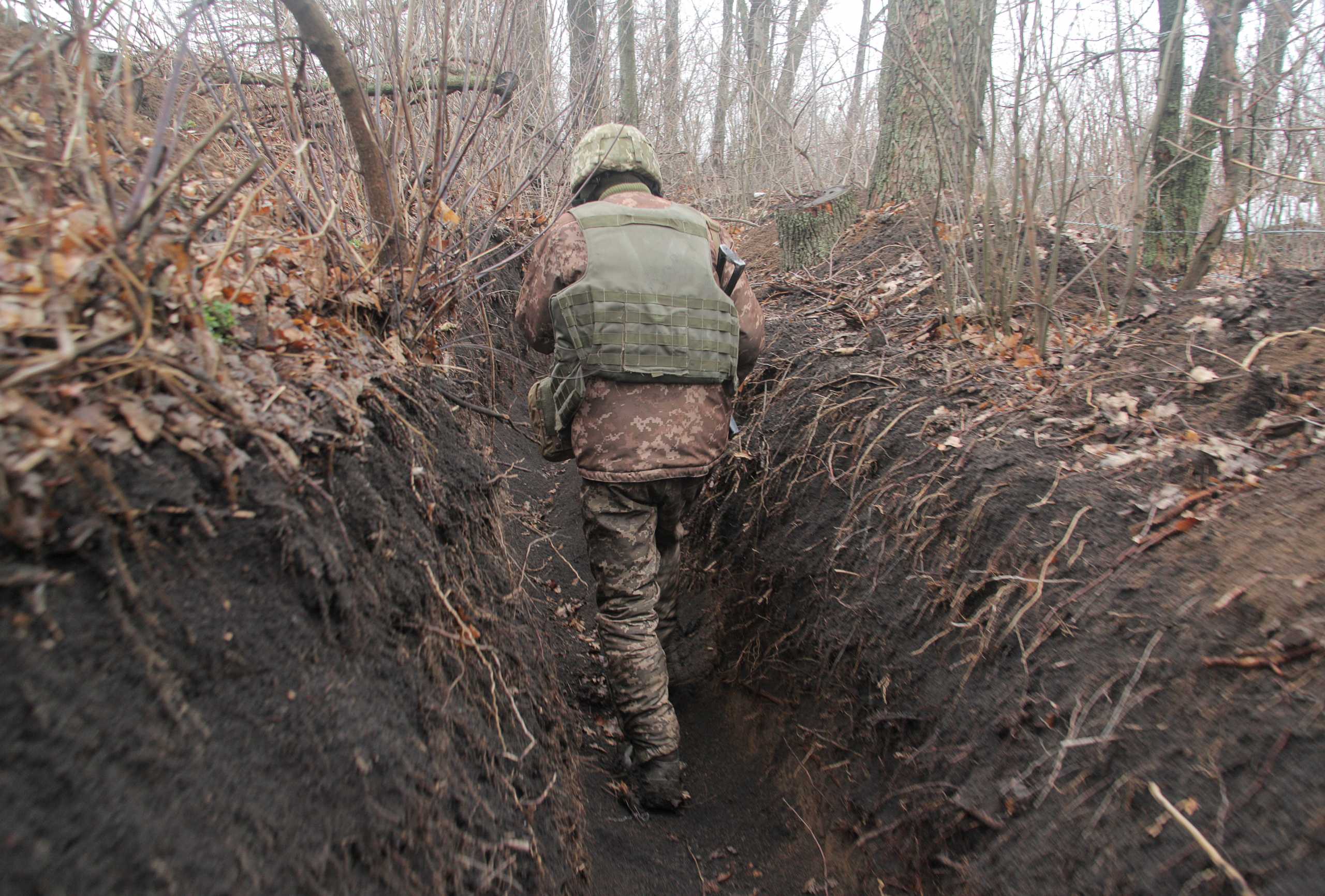 A service member of the Ukrainian armed forces walks at fighting positions on the line of separation near the rebel-controlled city of Donetsk, Ukraine April 3, 2021. REUTERS