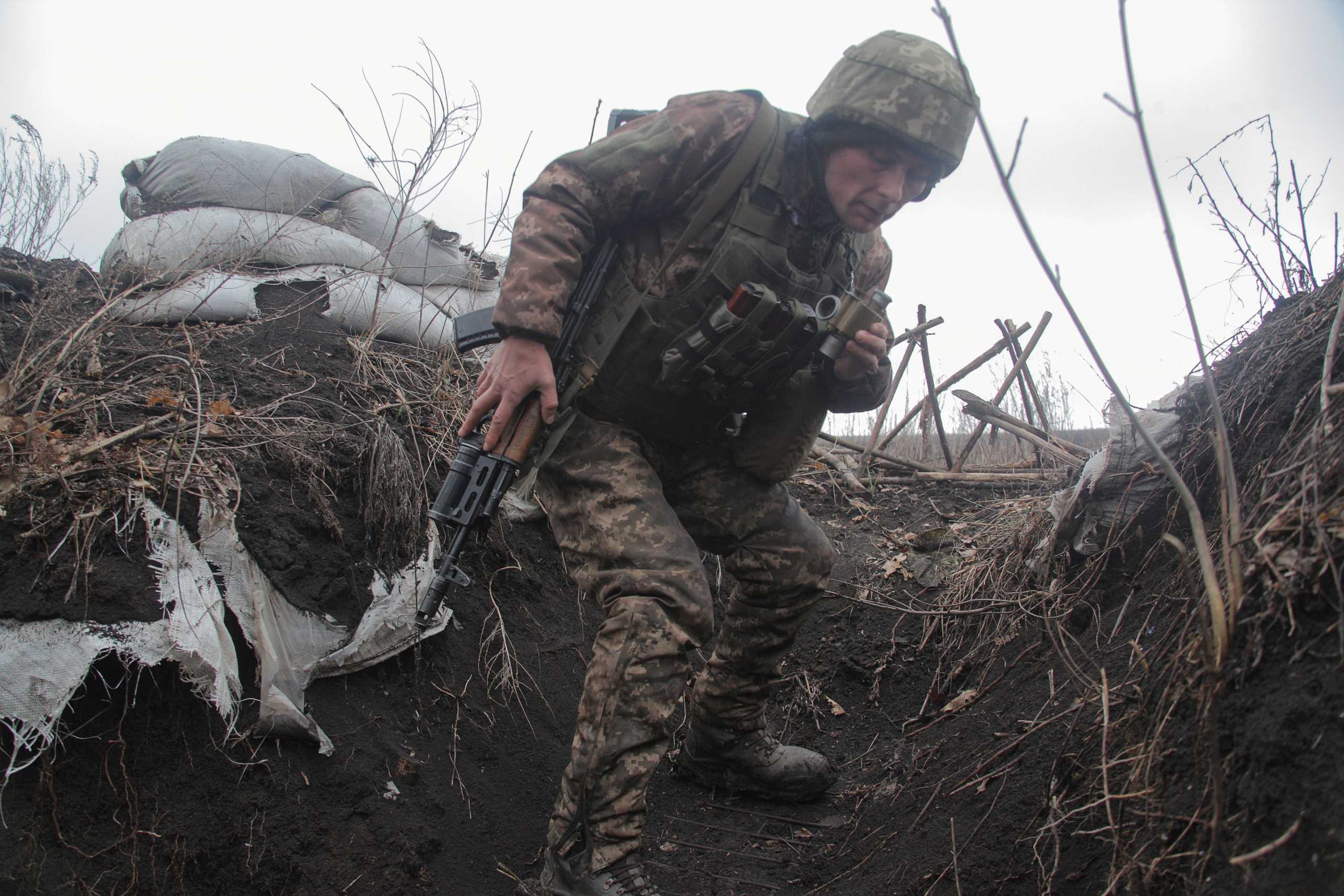 FILE PHOTO: A service member of the Ukrainian armed forces is seen at fighting positions on the line of separation near the rebel-controlled city of Donetsk, Ukraine April 3, 2021. REUTERS