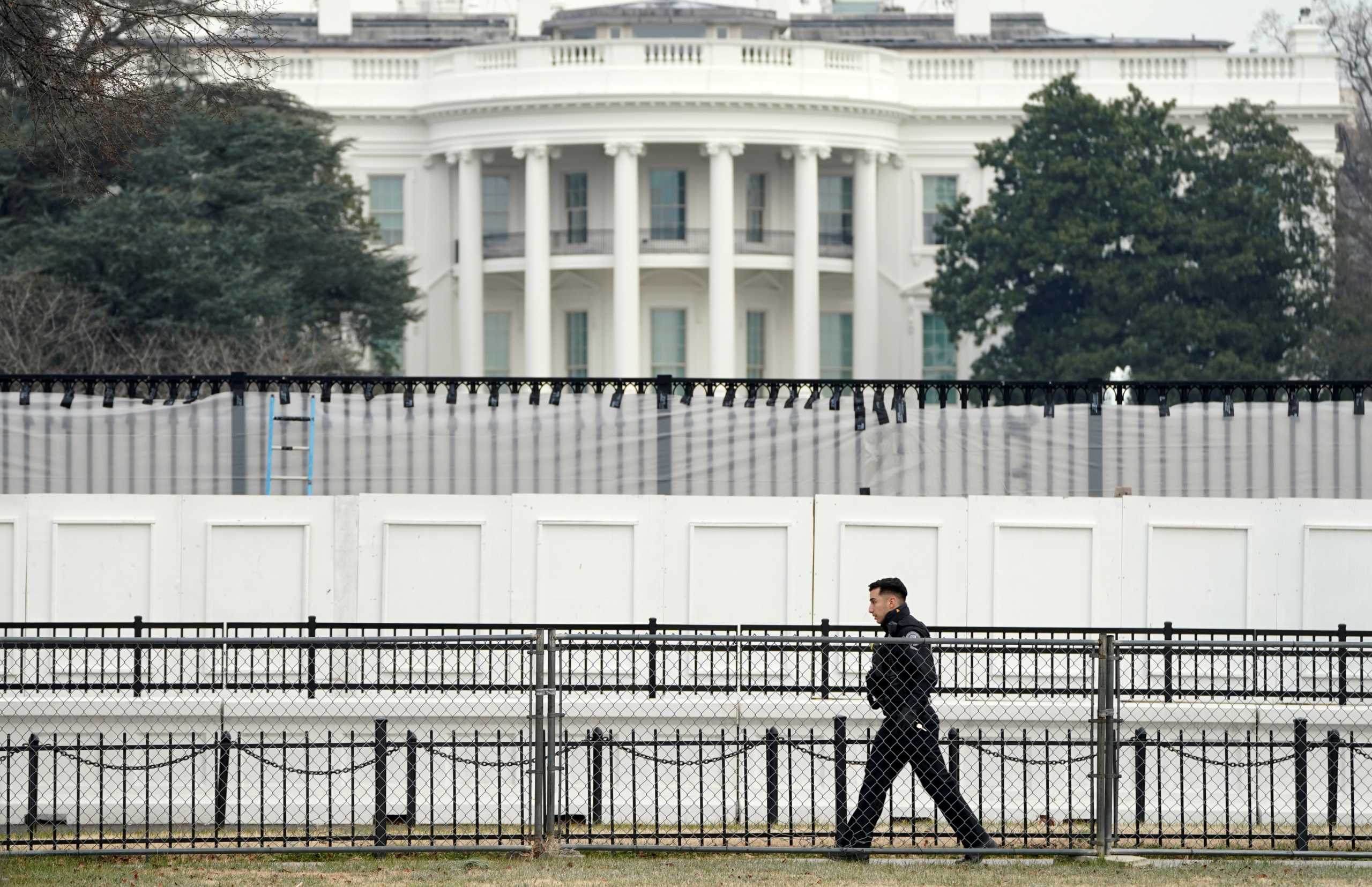 FILE PHOTO: A member of the Secret Service walks along security fence installed around the White House days after supporters of U.S. President Donald Trump stormed the Capitol in Washington, U.S., January 11, 2021.  REUTERS