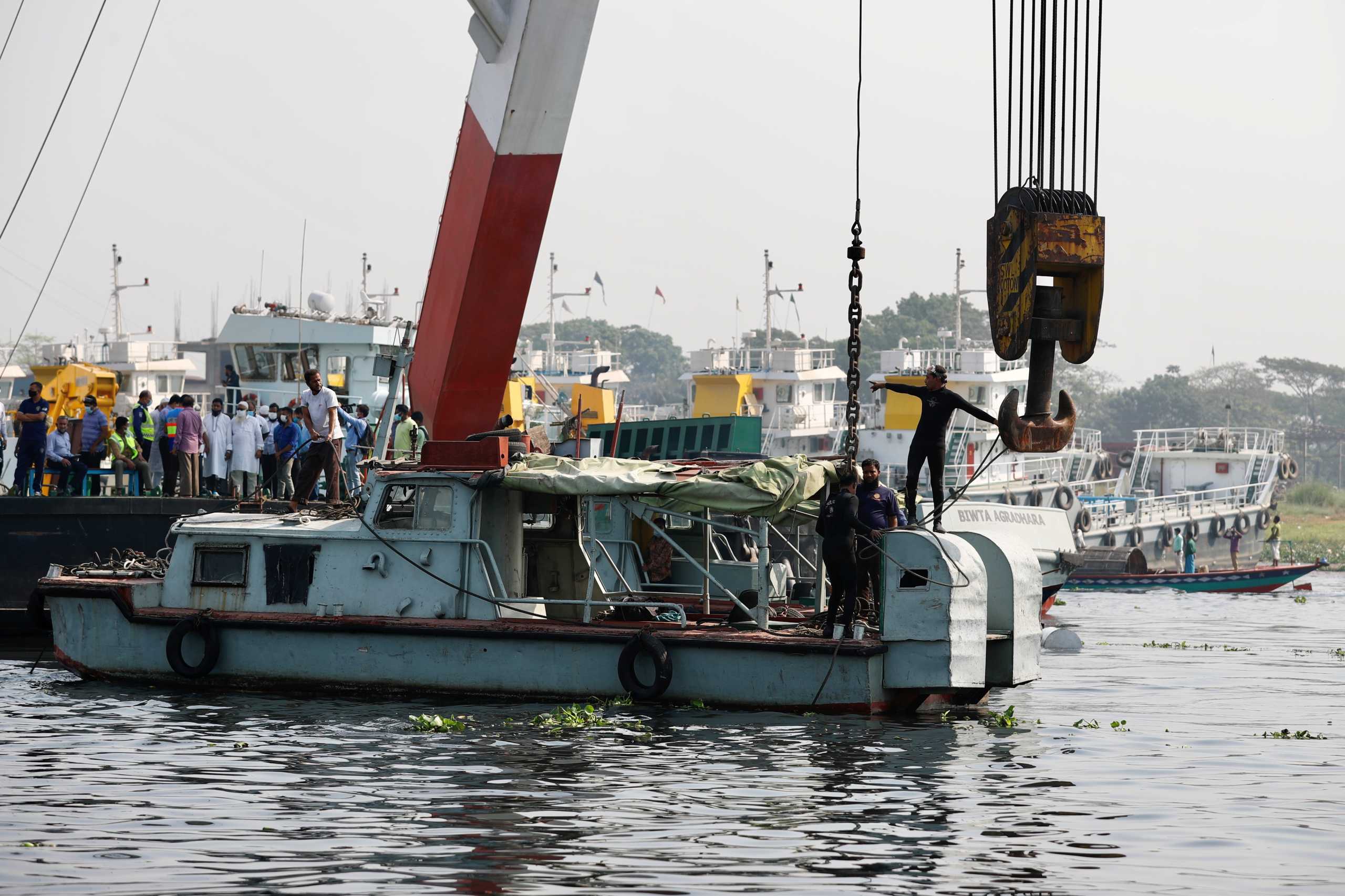 Rescue workers are on duty to rescue the ferry that collided with a cargo vessel and sank on Sunday in the Shitalakhsyaa River in Narayanganj, Bangladesh, April 5, 2021. REUTERS