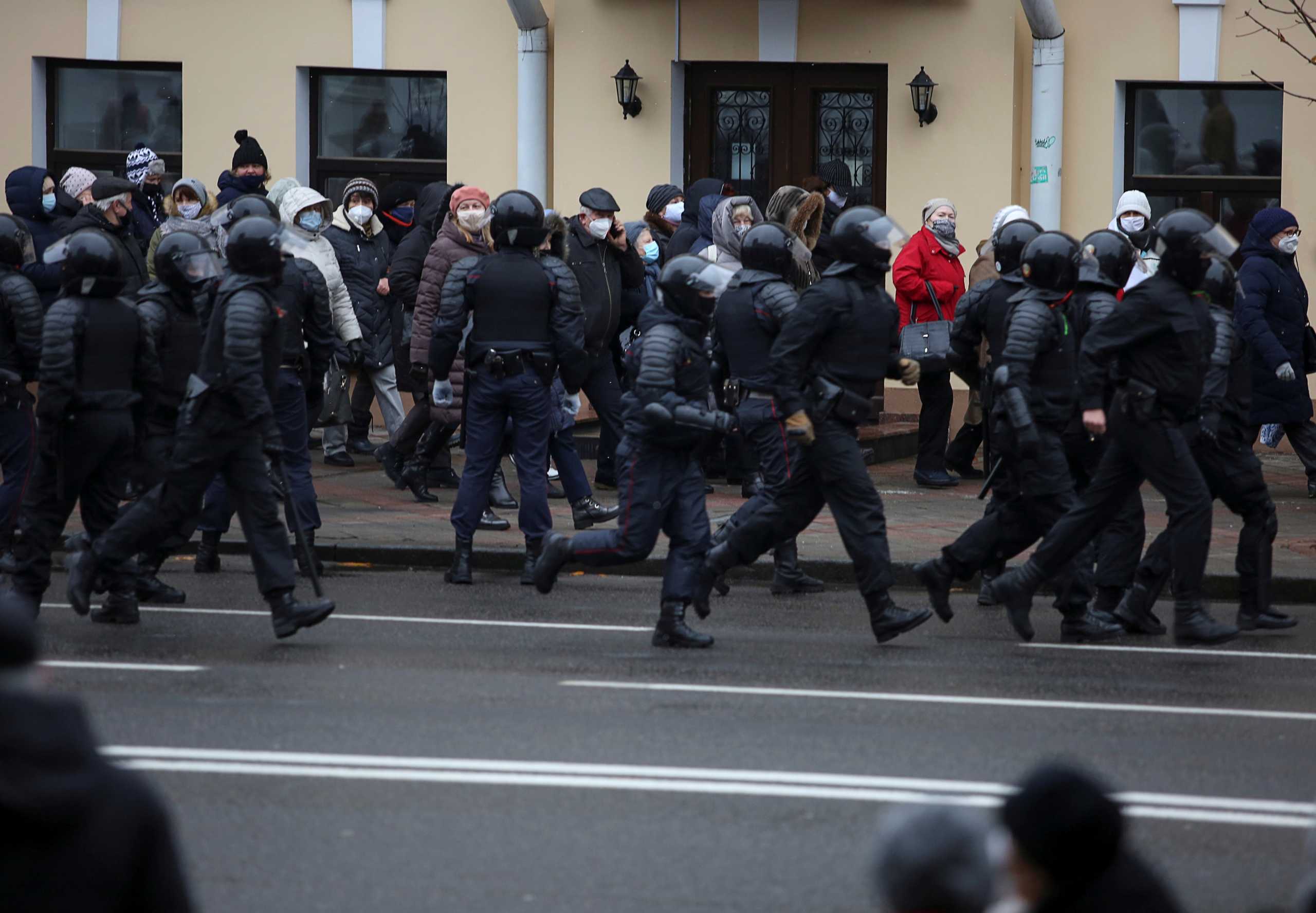 FILE PHOTO: Belarusian law enforcement officers follow participants of an opposition rally demanding the resignation of Belarusian President Alexander Lukashenko and protesting against police violence in Minsk, Belarus November 30, 2020. REUTERS
